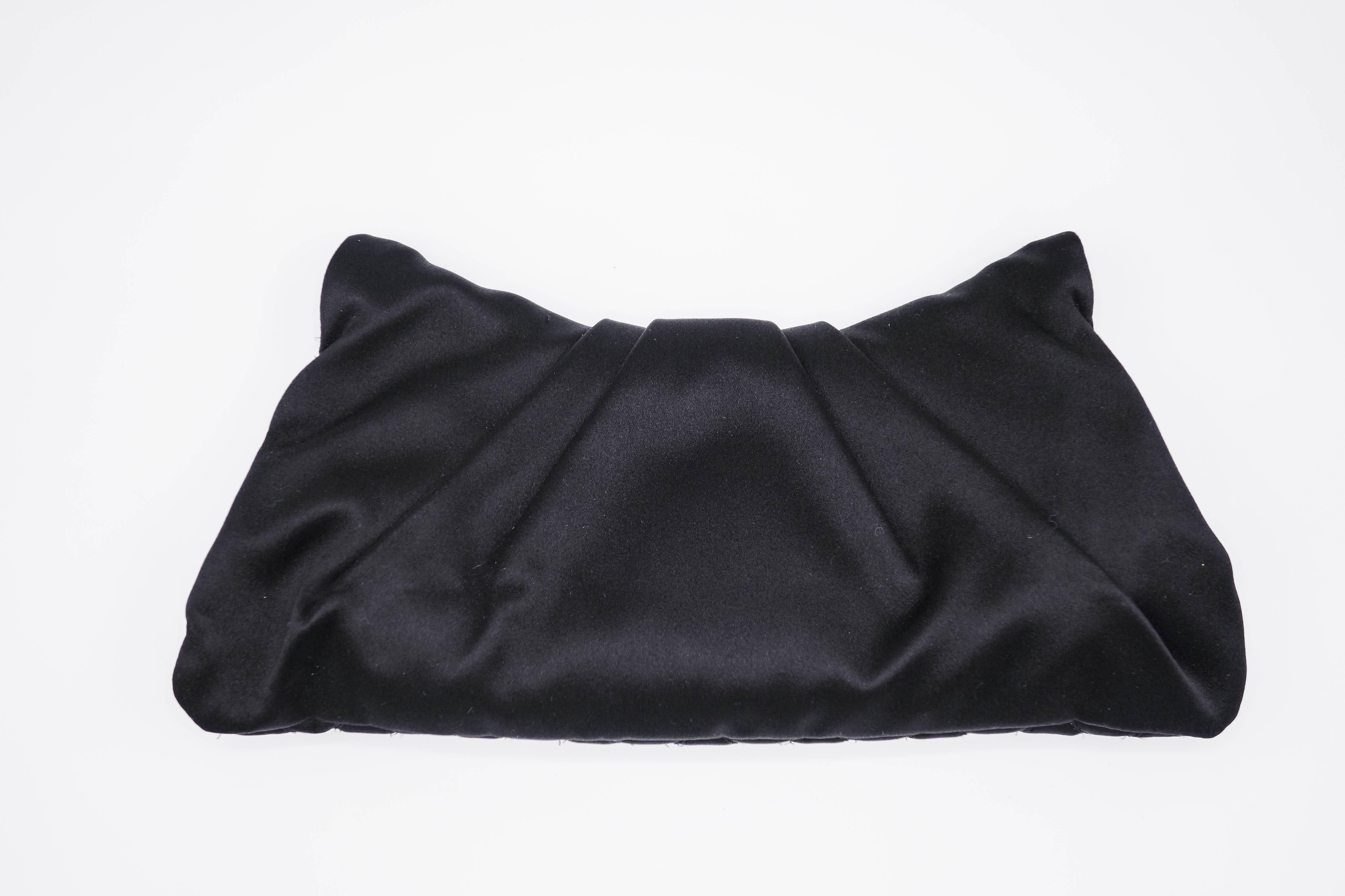 Chanel Black Quilted Satin Half Moon Silver Interlocking CC Clutch in excellent condition with no visible signs of wear. This satin clutch is very elegant and can be used in every formal occasion. This bag is lined with satin lining, single pocket