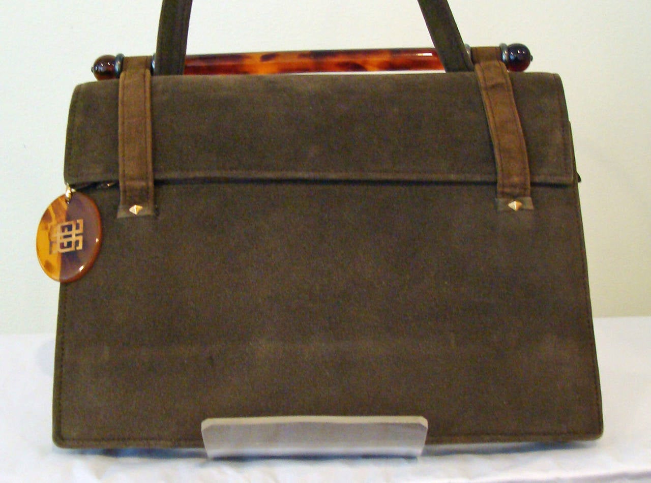 One of our local Buck County collectors brought in this exquisite little handbag, wrapped in tissue.   The body of the bag is a fine suede and the closure is a tortoise glass rod which retains the front handle.  Just under the flap, there is a