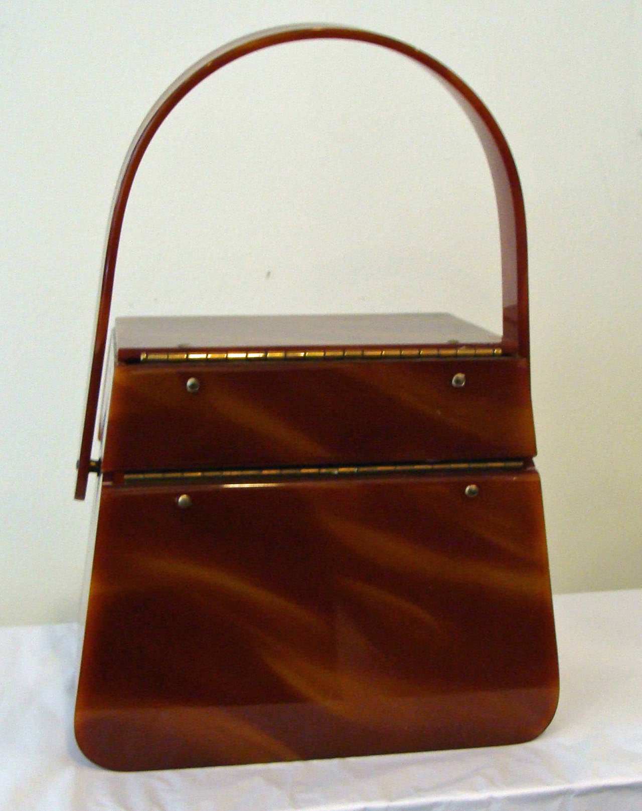 This rare and lovely Lucite purse is made of a rich tortoise style Lucite.  The  purse was produced by well-known Wilardy Originals has a single handle and sleek design.  

This bag was recently consigned to our gallery by a local Bucks County,