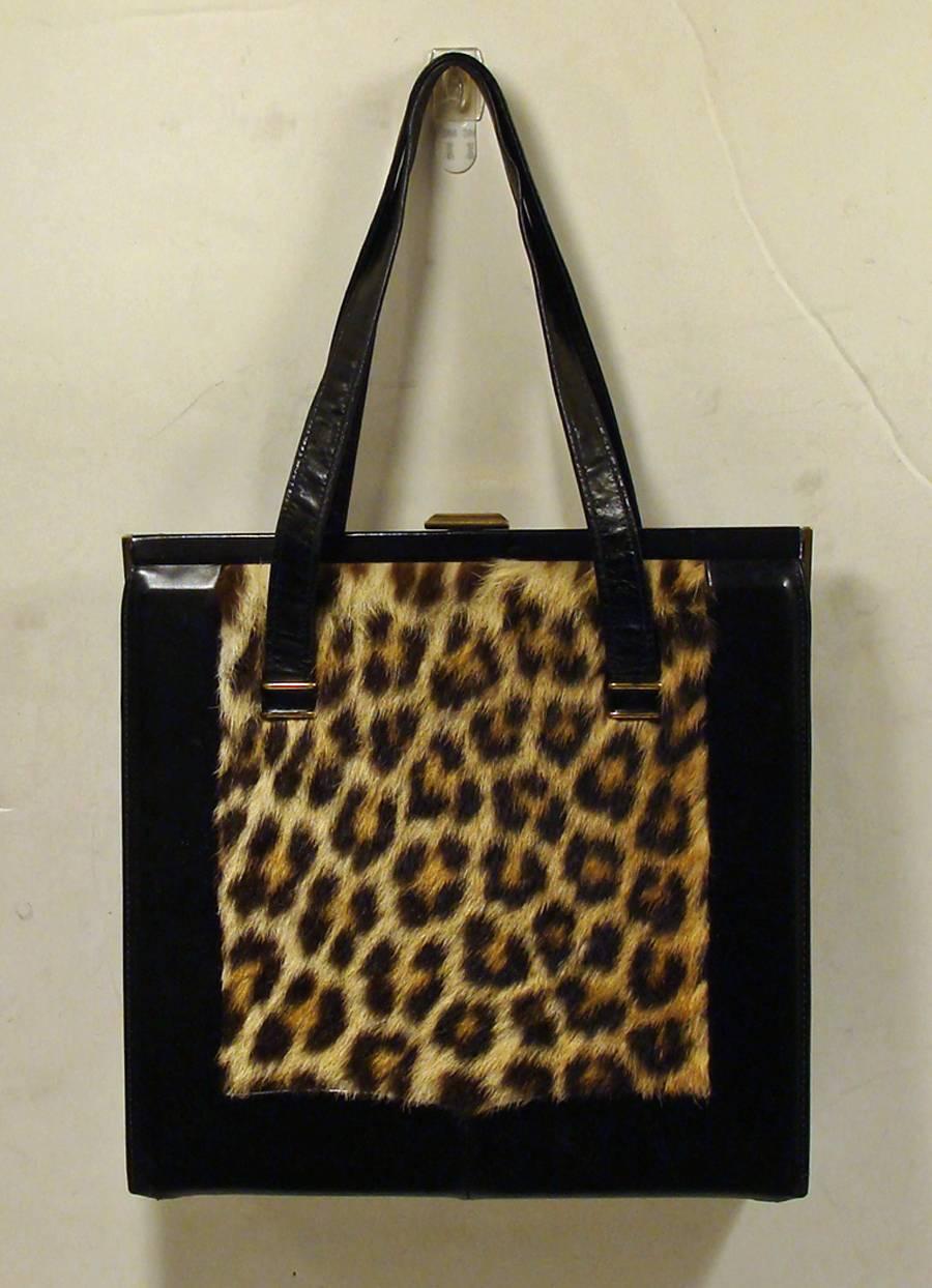 Animal prints are classic and always fashionable.  This bag is no exception. 

This double handle purse has black leather handles and trim and a vibrant leopard style print on both the front and back.  

The interior is in black leather and has