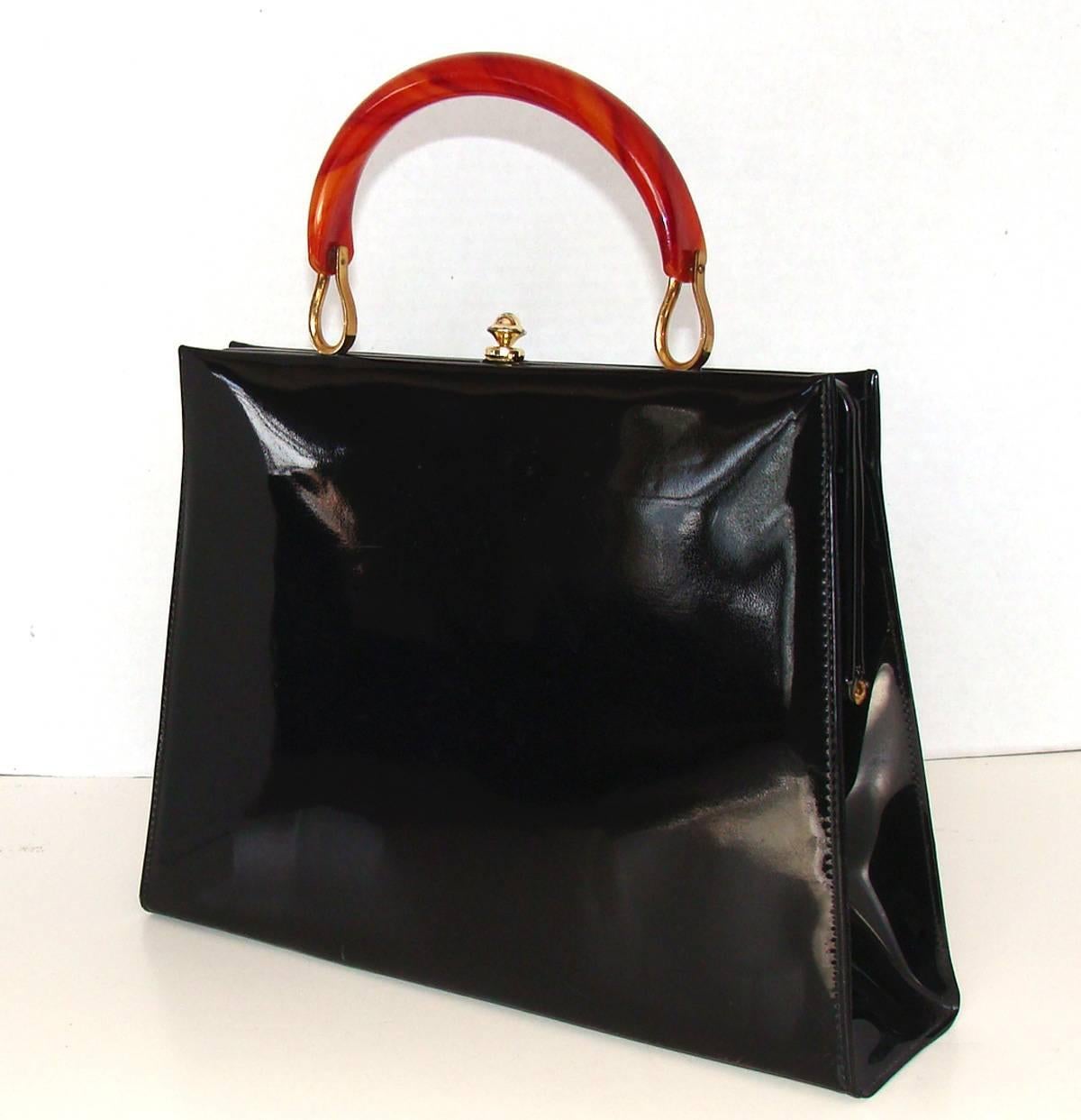 Timeless and classic patent kelly bag with tortoise style lucite handle mounted with stylish brass mounts.  

This spacious bag is practical and is good for dress and casual from NYC to LA.  

It is in nice vintage condition, with no issues, showing