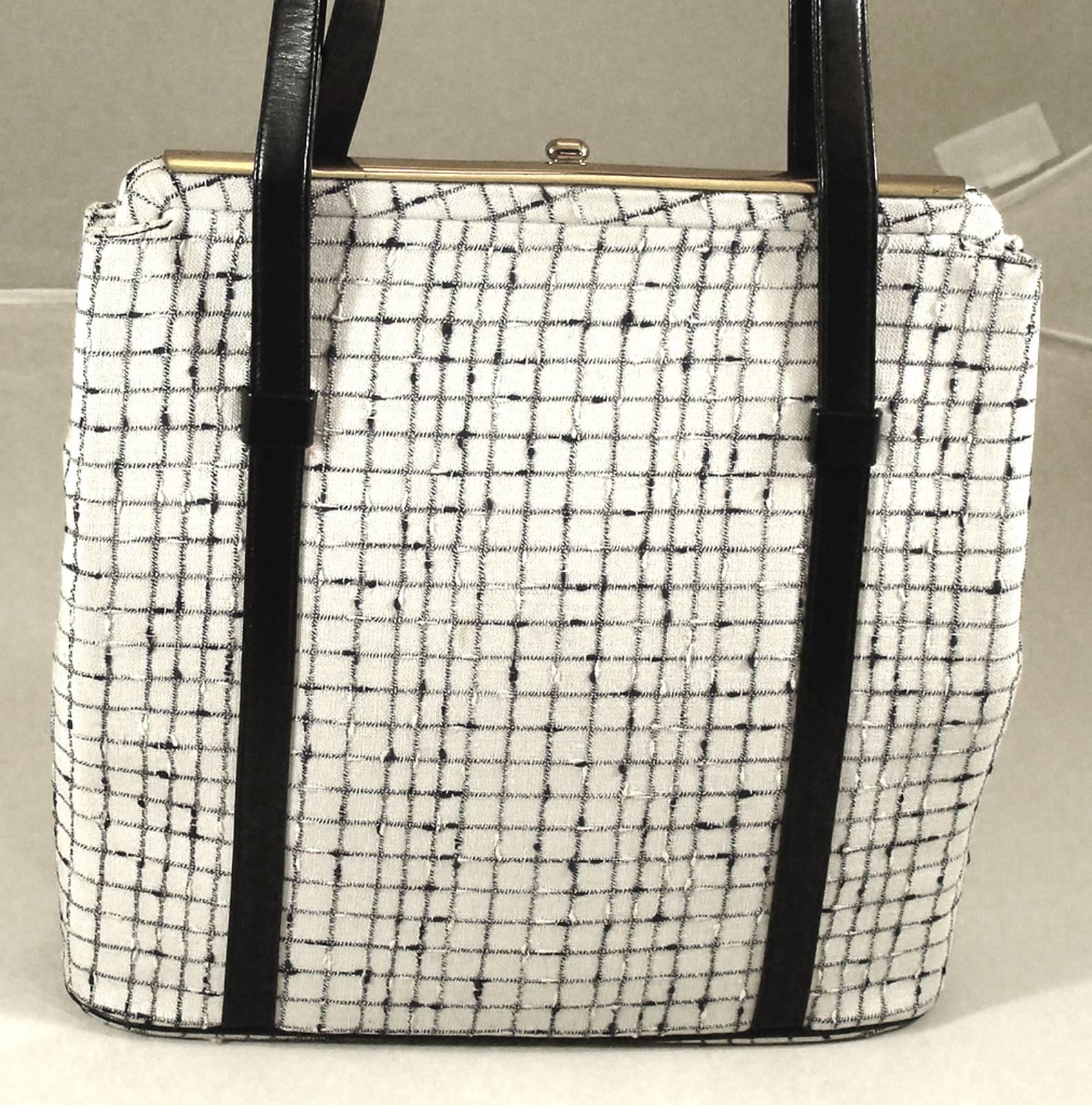 This charming bag double handle bag is a welcome consignment from one of our long-time collectors.  She has a great eye and we appreciate being able to offer unusual pieces from her collection.  

This purse is made of a plaid fabric of creamy white