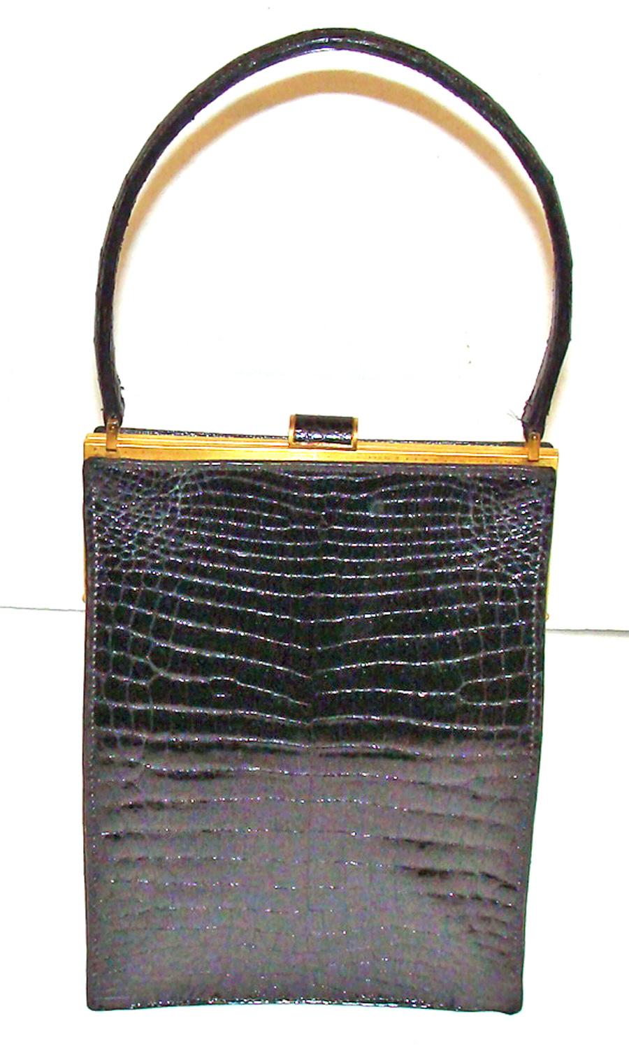 This is a rare alligator bag with an unusual vertical form.  The center skins on the front and back are the best small scale and gorgeous.  The label is stamped in gold on the interior leather lining and says:  Christian Dior Boutique.

The handle