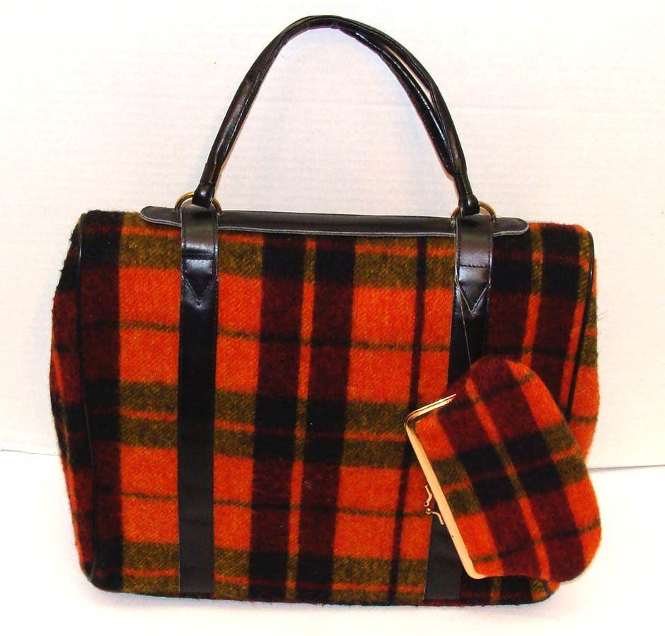 Here is a fabulous and rare orange plaid wool bag with matching clutch (see back photo).
The piece can be expanded to us as an overnight bag or carry your laptop & papers with flair.  

The handle and locking straps are black leather and the handle
