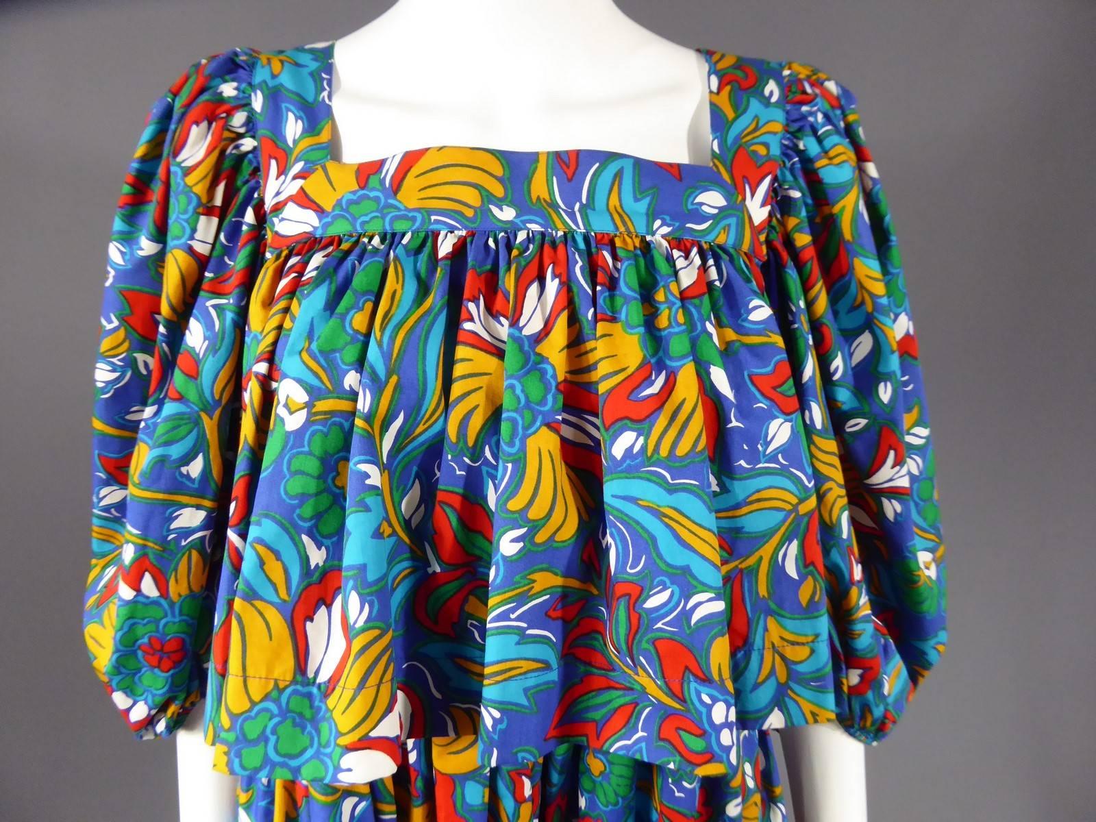 Circa 1980

France

Yves Saint Laurent Rive Gauche dress inspired by the Russian ballet Haute Couture collection. Multicolored floral print in shades of blue, and red. Boat neck and three quarters long puffed sleeves. Dress fitted underneath the