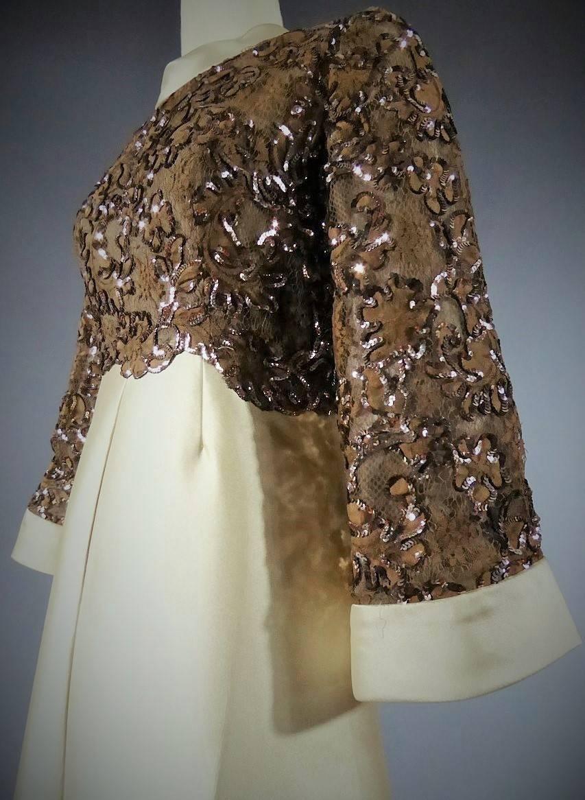 Circa 1970

France

Pierre Balmain "Florilège" dress numbered 9173 worn by Bathsabée in brown lace. Laces from Calais (?) with flower and leaves patterns embroidered with brown sequins. Lace patterns are cut to mark the waist. Flared skirt