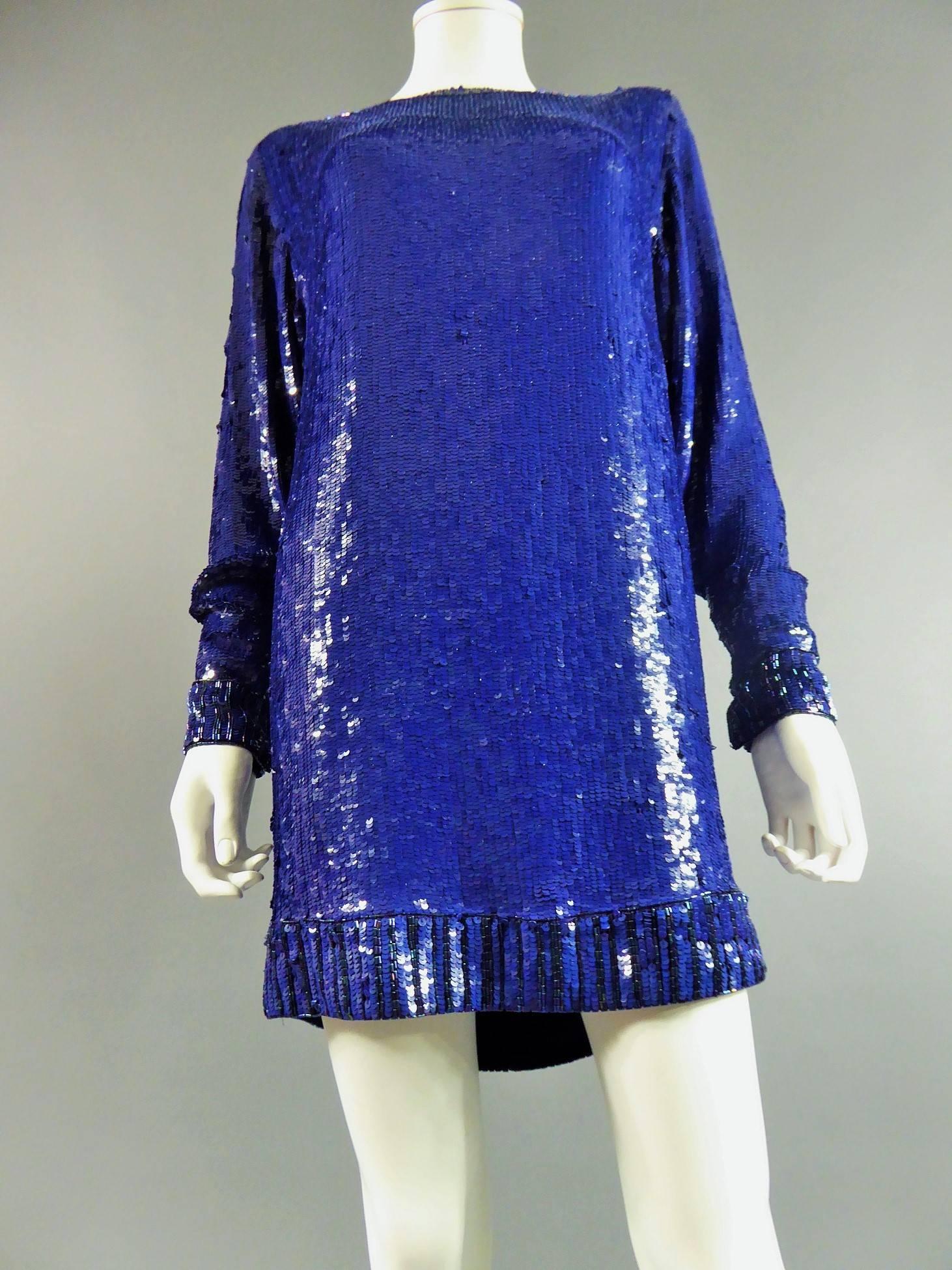 Circa 1980

France

Sweater or sweater dress by Saint Laurent Rive Gauche in majorelle blue color. Sweater dress covered with blue sequins. Collar, sleeves and bottom of the sweater decorated with round and blue tubular and seed beads. Sleeves