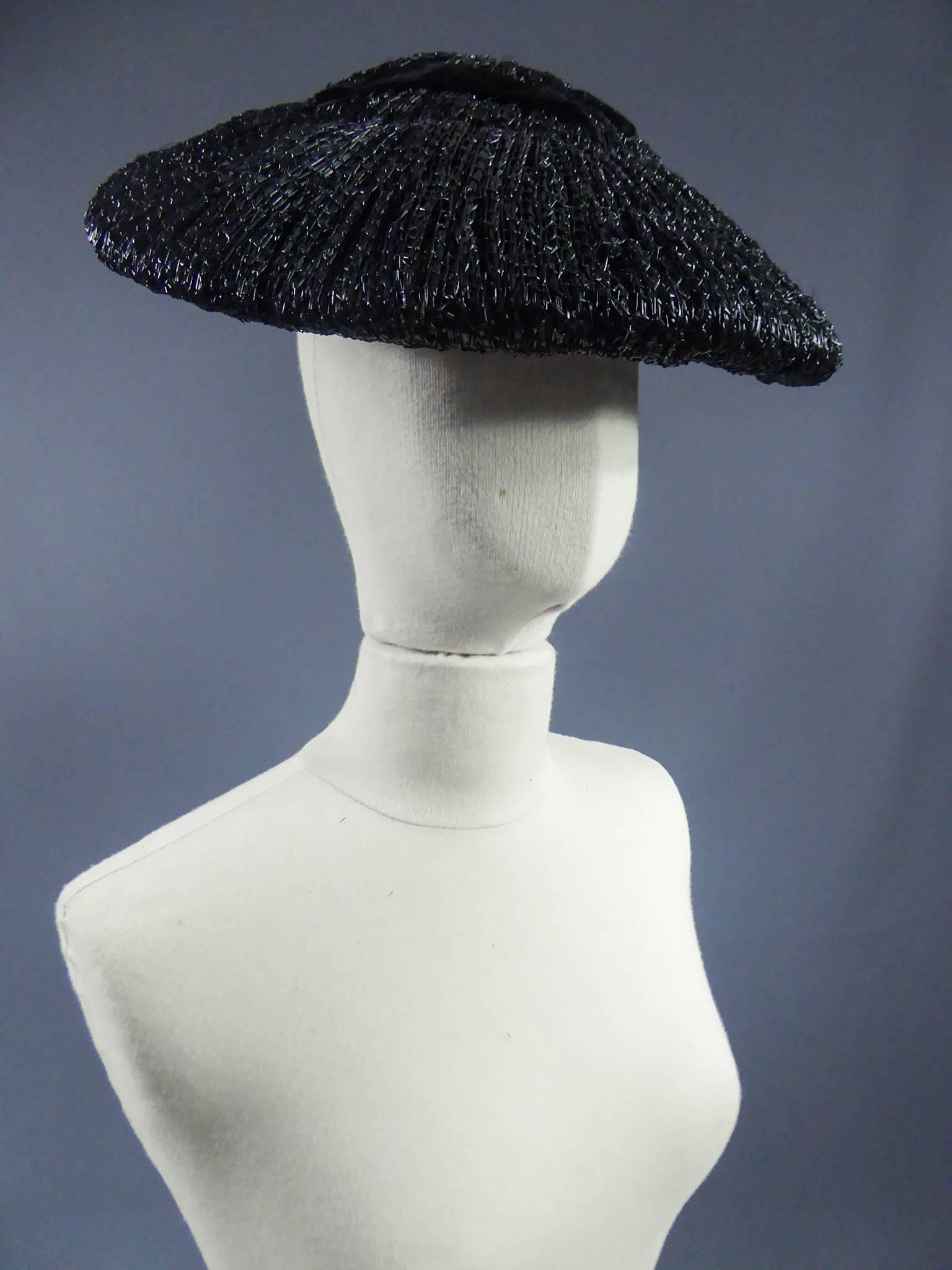 Circa 1947

France

Black straw hat with black velvet ribbon in the style of the New Look era Bar Suit silhouette from 1947. Ribbon inside.

Measurements : largest diameter 36 cm.
smallest diameter 35cm. gros grain interior : 15.5 cm.


