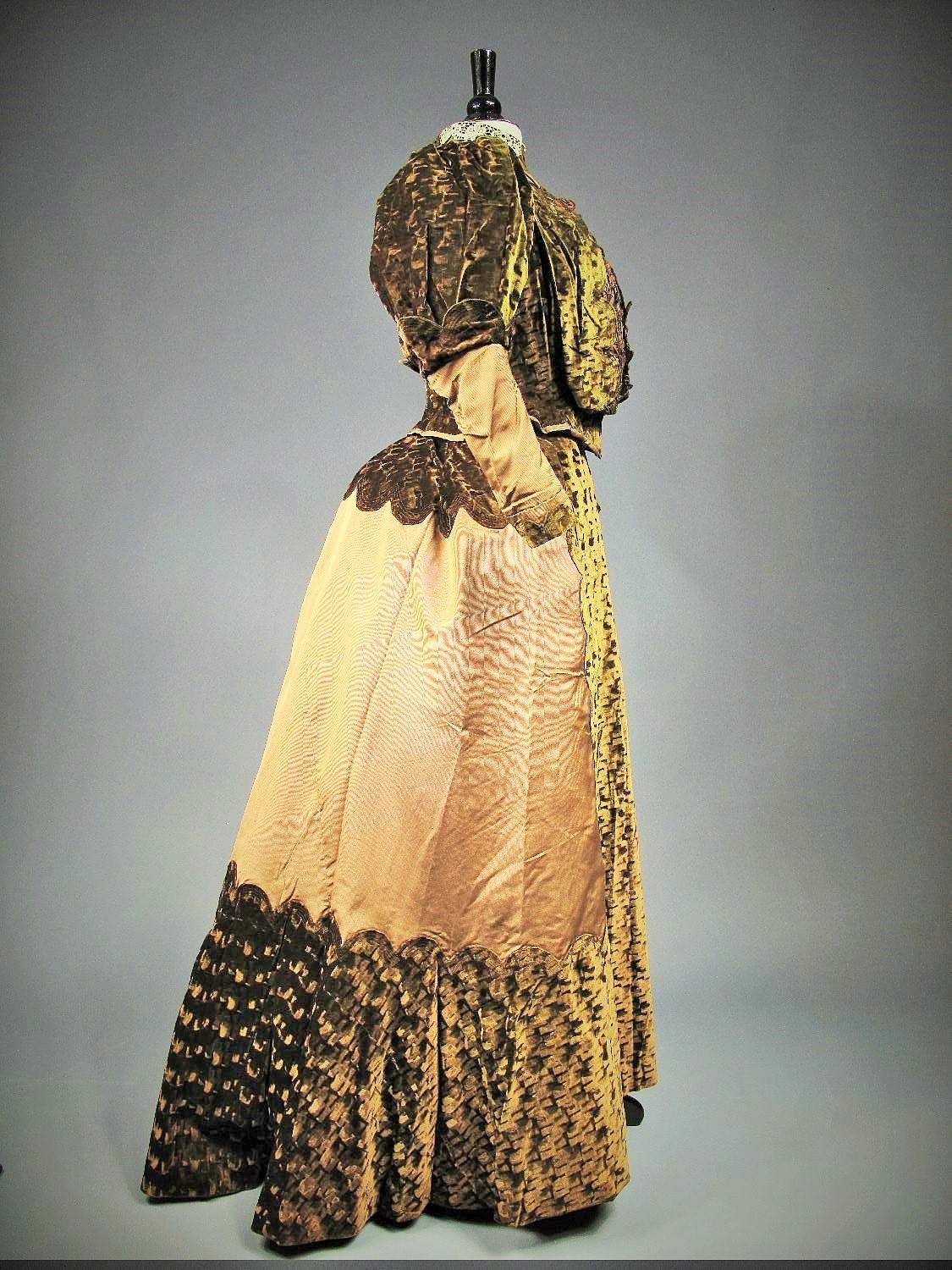 Circa 1900
France Paris

Two piece day or walking dress in green khaki waffled velvet on a chocolate silk ground. Boned bodice embellished with floral French « Art nouveau » embroidery in the "Style Nouille" made fashionable in Paris by