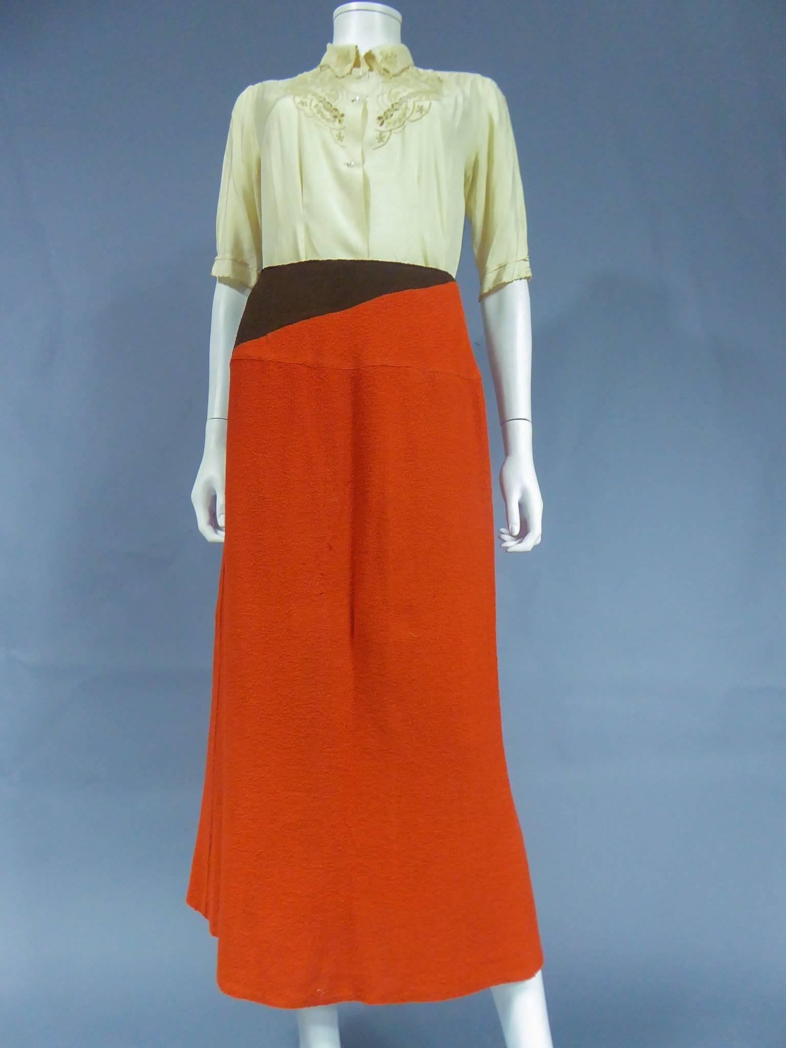 Circa 1935

Paris, France

A brown and brick red skirt suit ensemble in wool with a cream blouse by France Barière, circa 1935. Long skirt falling above the ankle, bouclette wool brick red enhanced with a brown asymmetrical band at the waist.