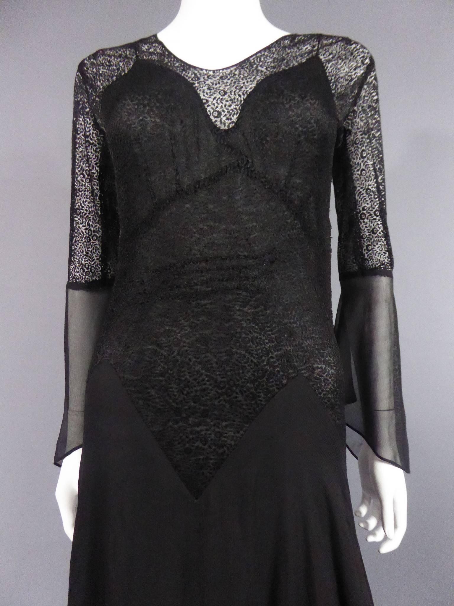 Circa 1935/1950

Madrid, Espagne
 
Long Haute Couture dress by Cristobal Balenciaga EISA. Dress with black silk crepe skirt and black silk guipure top with small flowers. Flared sleeves from the elbow. Snap closure on the side of the waist. Black
