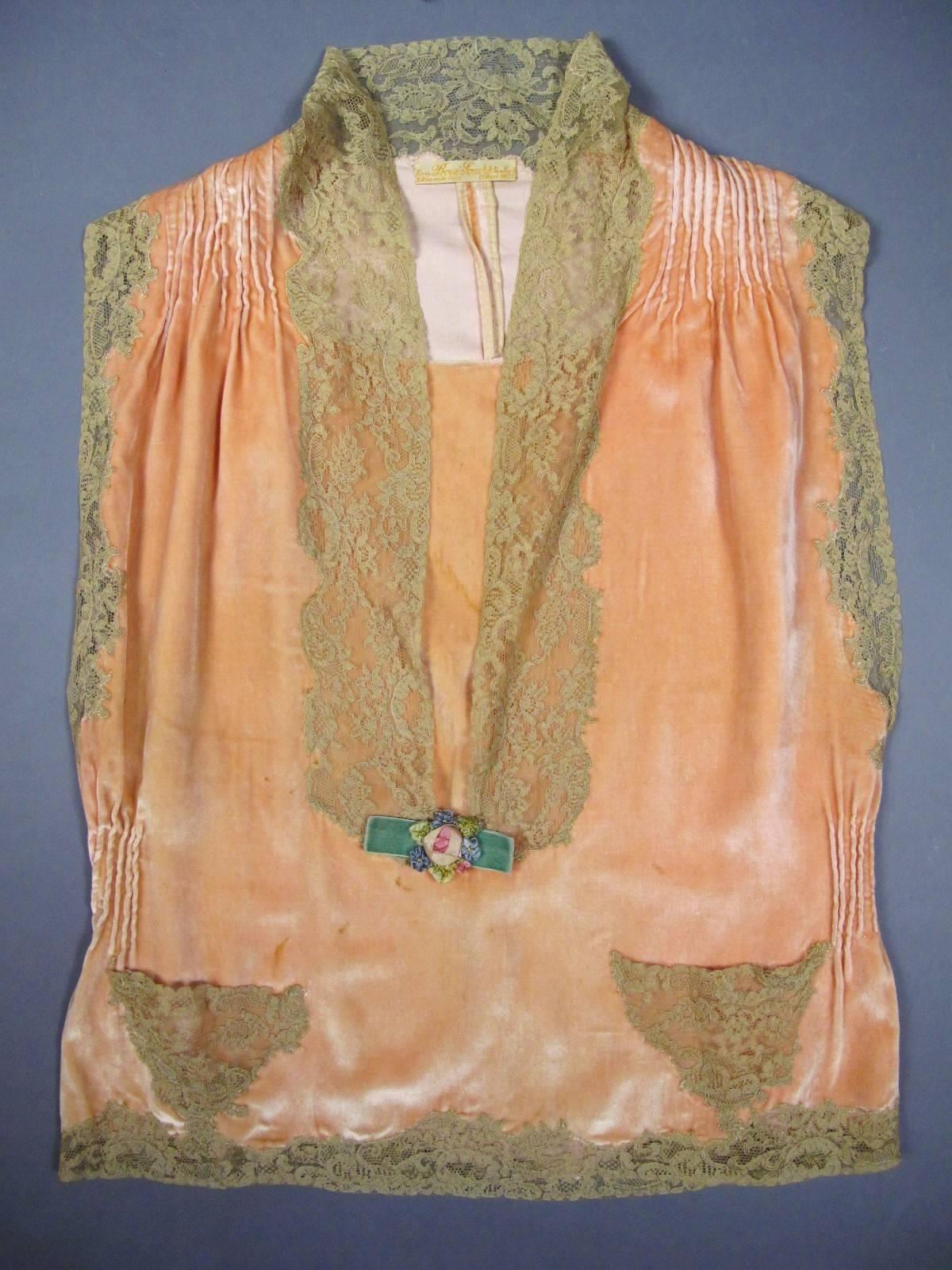 Circa 1925
France Haute Couture
Negligee in salmon velvet labelled from the famous House Paris Boué Soeurs New York 9 rue de la Paix 13 West 56th street and dating from the period Art Deco. Borders of Calais lace and pale mandarine silk velvet . The