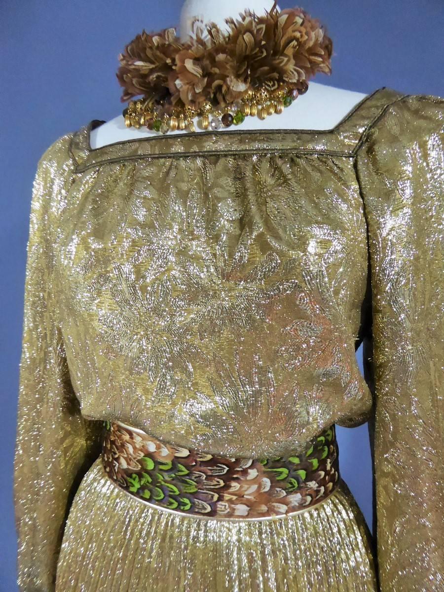 Yves Saint Laurent Haute Couture labelled and numbered 39875
Ballets Russes collection
Autumn Winter 1976-1977
The Abrahams gold-silk fabric is woven with leaves. The ensemble comprises a blouse with full sleeves, and a pleated skirt. The belt is