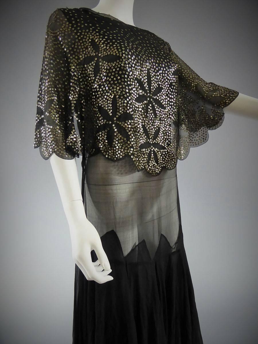 Circa 1935

France/Anonymous

Beautiful anonymous Couture dress in black crepe silk embroidered with silver sequins dating back from between 1930 and 1940. In bias cut in the backdrop of the dress. Bottom of skirt is sewn from the hips with a