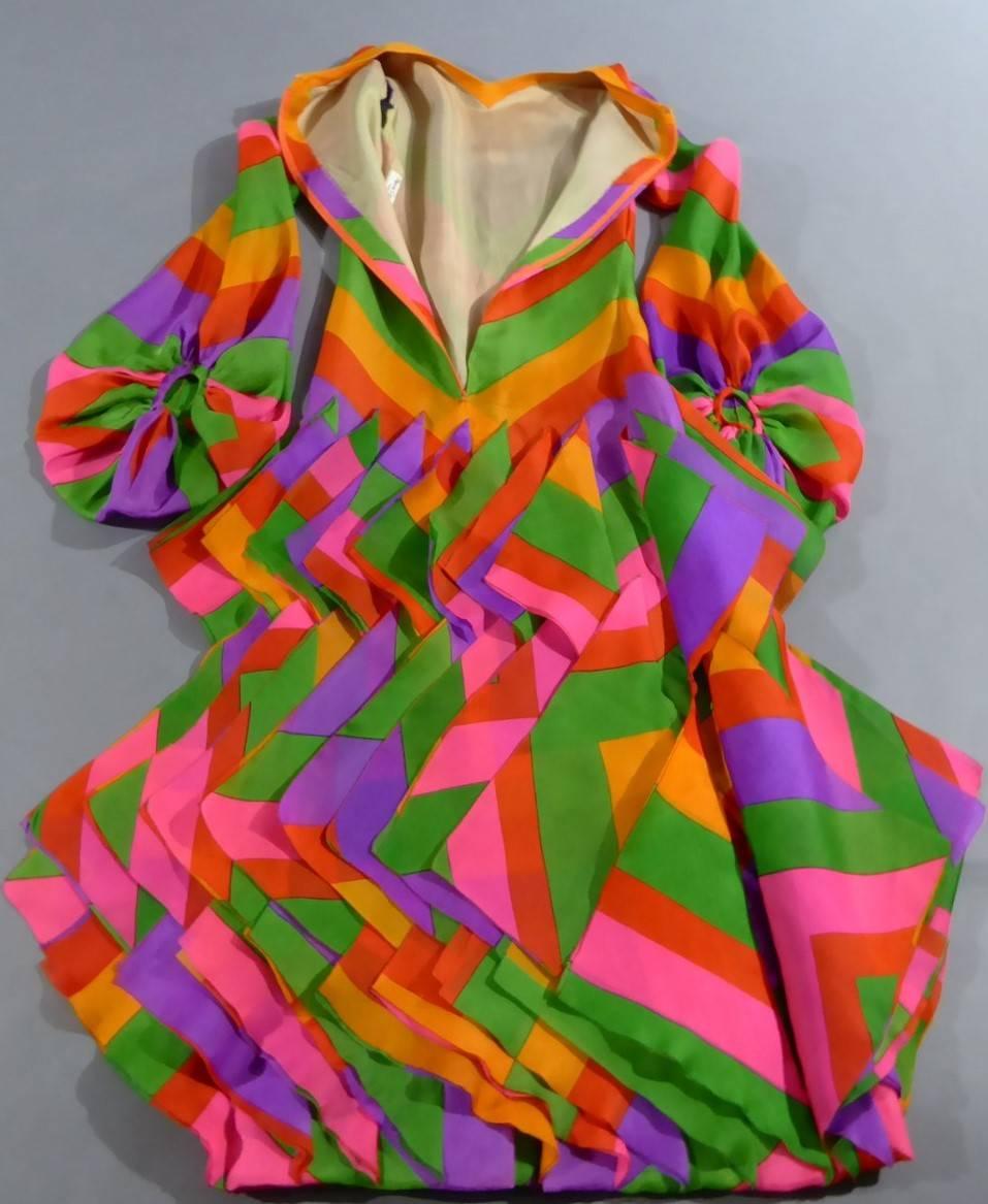 Circa 1970

France Haute Couture

Amazing Haute Couture long evening dress by Pierre Cardin Paris and dating from the seventies. Multicolored printed organza with large chevrons in yellow, orange, purple, green, fuschia and vermillon. Three ranks of