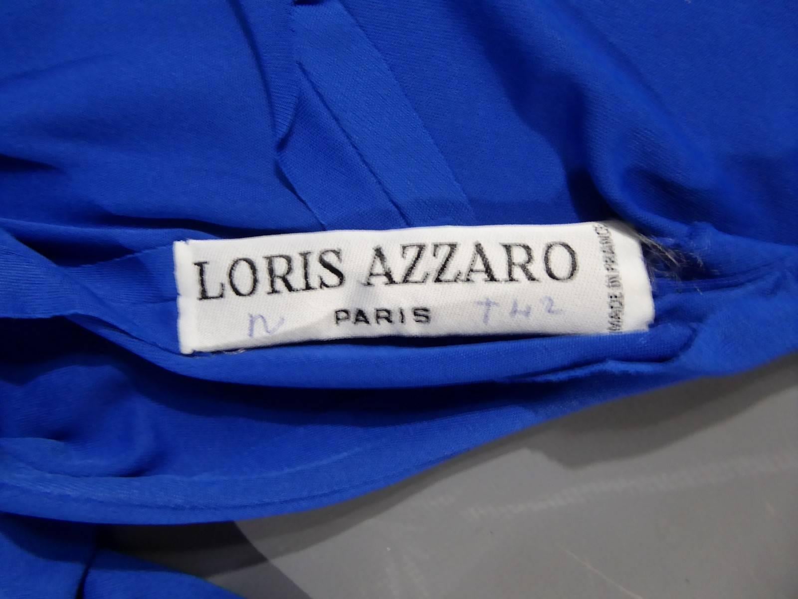 Circa 1990

France

Beautiful Haute Couture evening dress by Loris Azzaro Paris dating from the nineties. Long dress in electric blue mate Lycra. Large shoulder pads and mao collar in assorted sequins. Long sleeves. The dress is backless in an oval