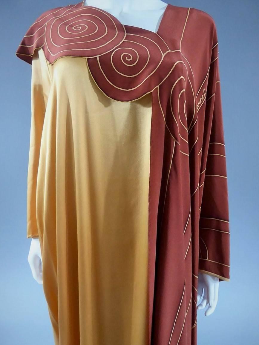 Circa 1985/90

London

Large english Couture evening dress labeled by Ian and Marcel and dating back from the end of the 1980s. Back of the dress in satin golden silk. Large collar, sleeves and lateral pannel in chocolate / terracotta crepe silk.