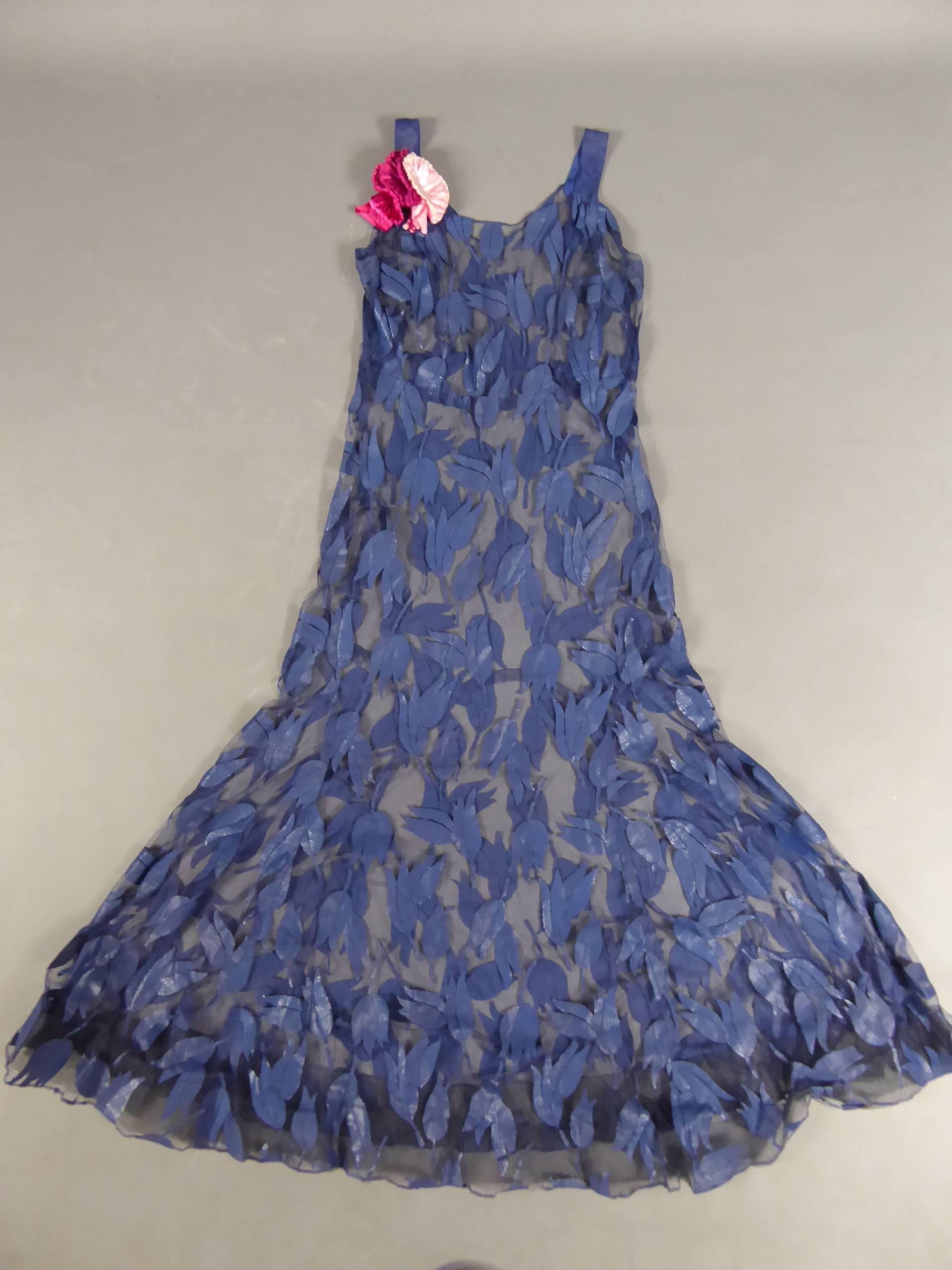 Circa1930 - 1940

 France

Deep blue tulle evening dress with tulips appliqué work from the years 1930- 1940. Reinforced bell skirt with a tulle rigid Bolduc for a fallen ruffled . Bouquet of artificial pink flowers on a shoulder. Two leg straps