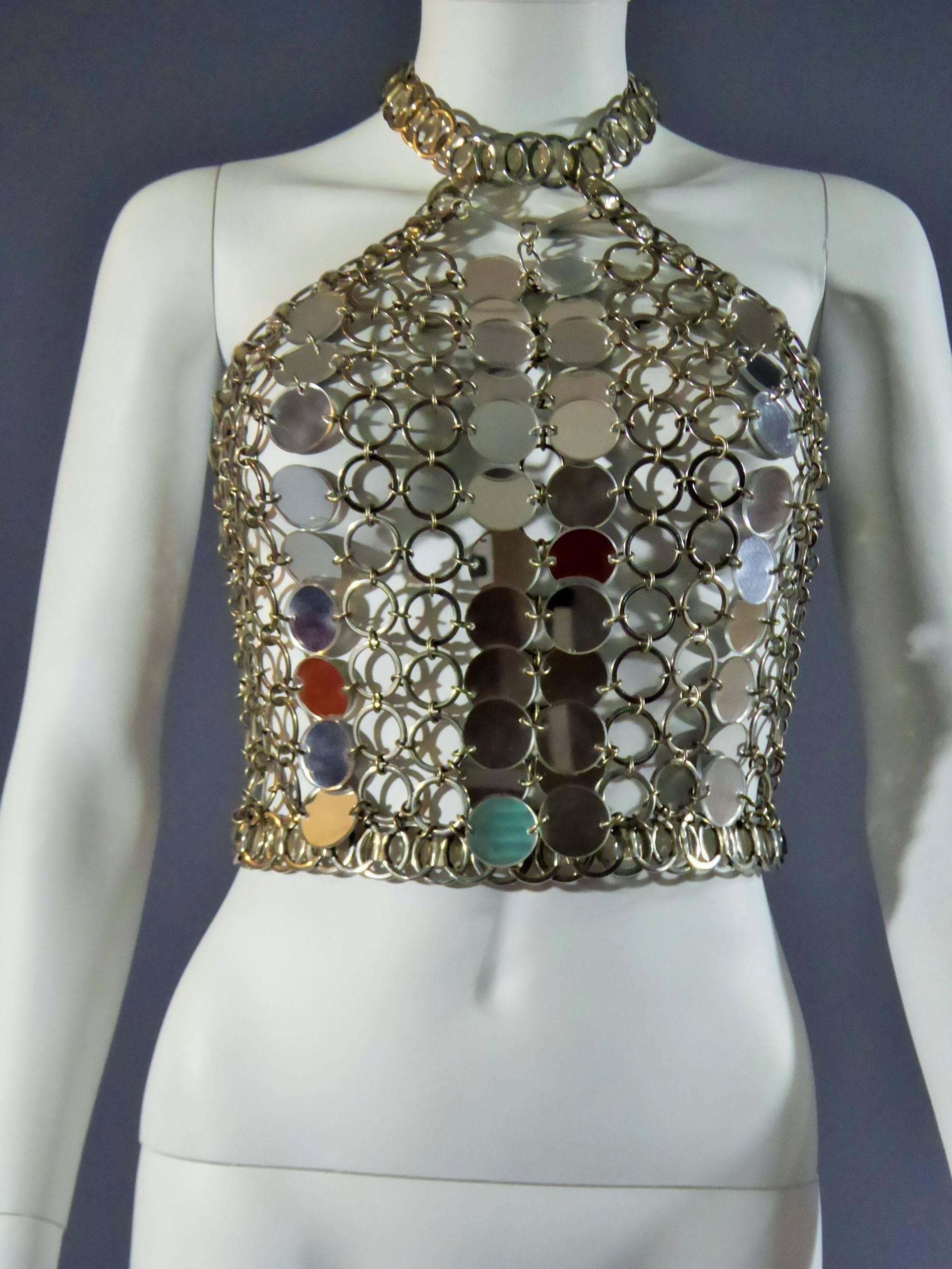 Circa 1970

Paris

Paco Rabanne Top from the first period of creation of the designer With Paco Rabanne label at the neck. Metal rings mesh, small disk mirroring and tape transparent rigid vinyl. Topless Scoop attached to a “collier de chien”