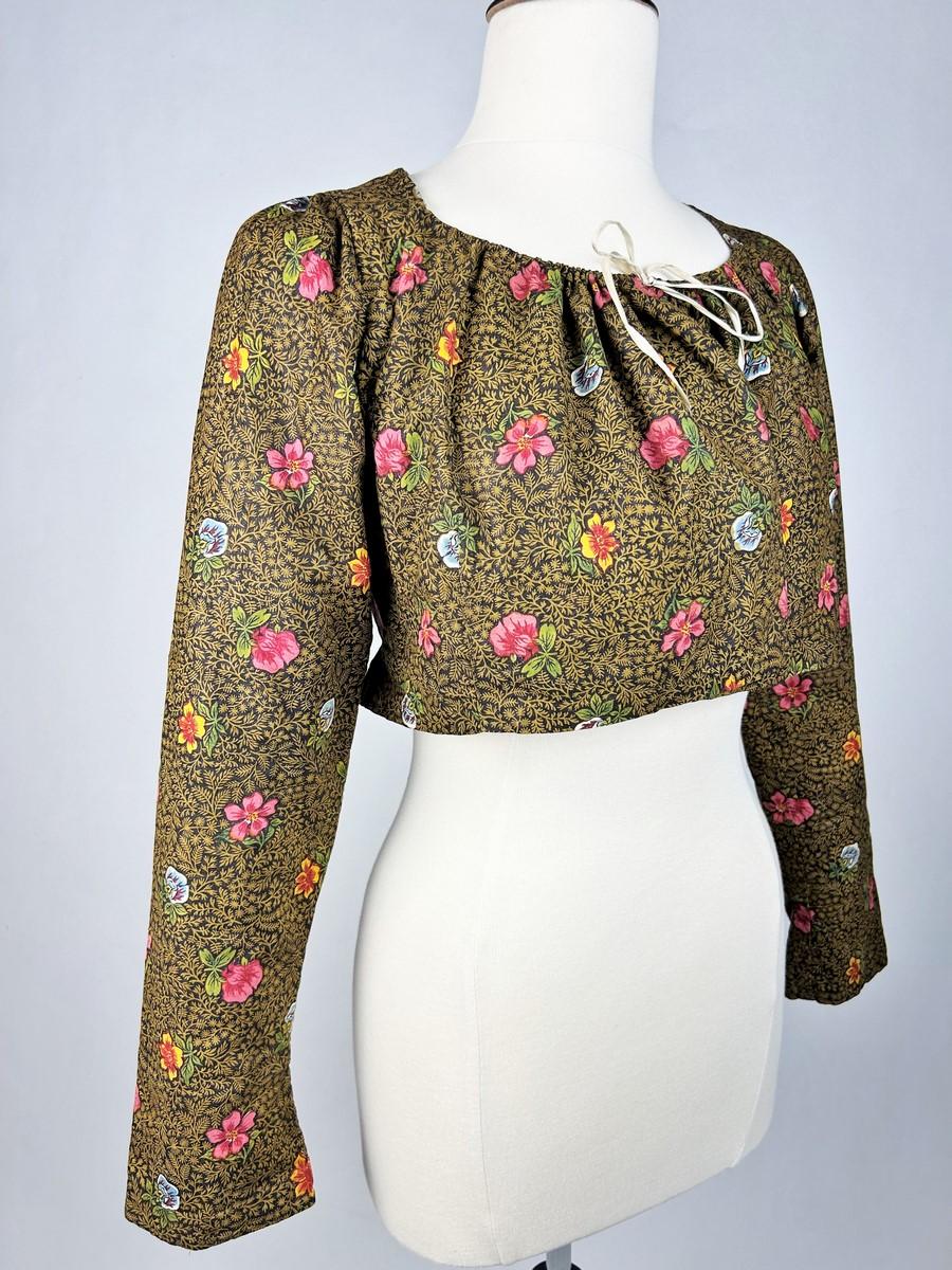 Circa 1790
Provenza
Un caraco de chintz de la Manufactura Oberkampf de Jouy-en-Josas. Impresión xilográfica sobre fondo ramoneado con motivos florales llamados Bonnes Herbes. Corte de talle alto con mangas largas tubulares acabadas en puño de