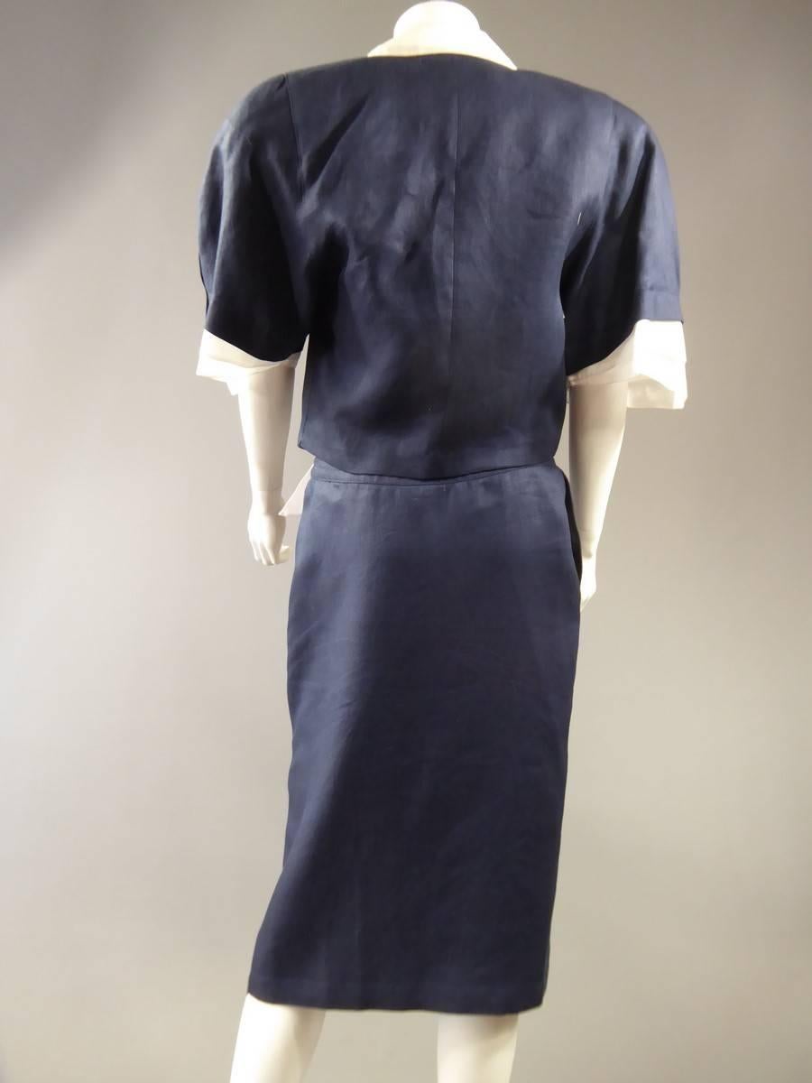 Circa 1980

France

Skirt suit and jacket by French designer Claude Montana. Label is white with Claude Montana Paris Made in Italy written in gold. Made of blue navy linen and white borders in cotton. 3/4 sleeves with wide shoulders finished by a