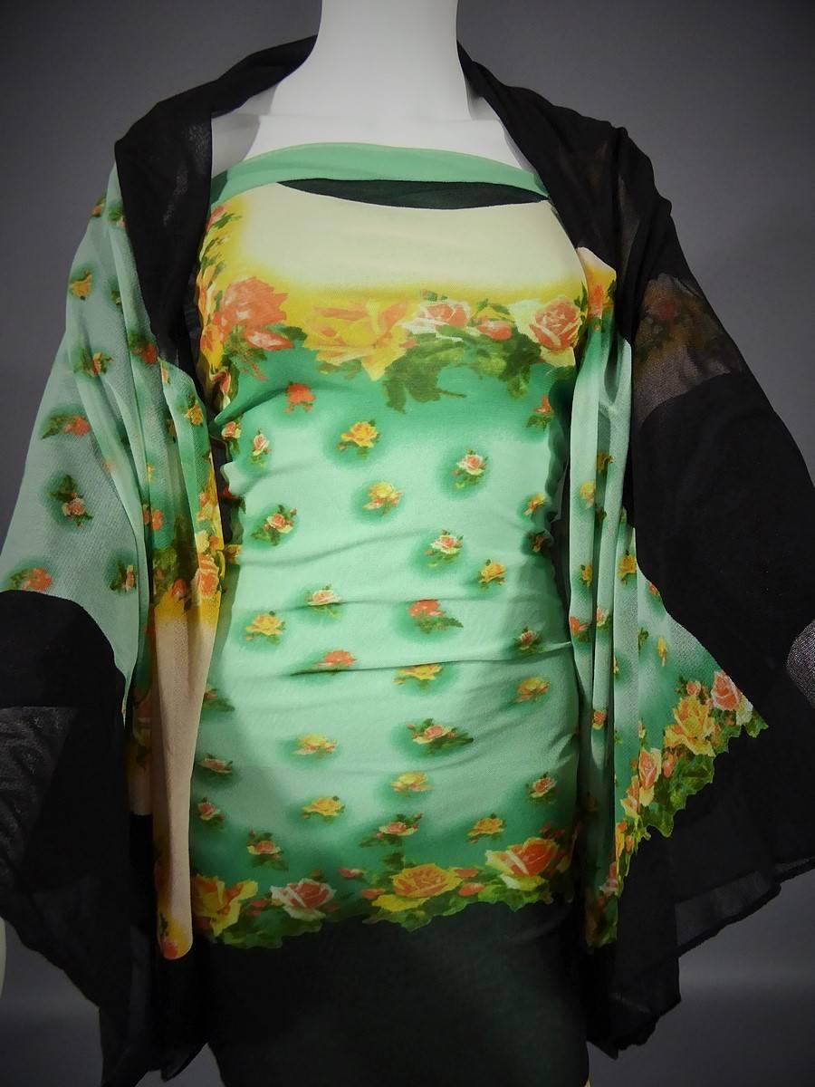 Circa 2000.

France.

Long dress by Jean Paul Gaultier, in printed tight and stretch knit. Impression trompe l'oeil of a water green bustier and yellow and orange roses on a black background in an asian style. Lining in the same color material
