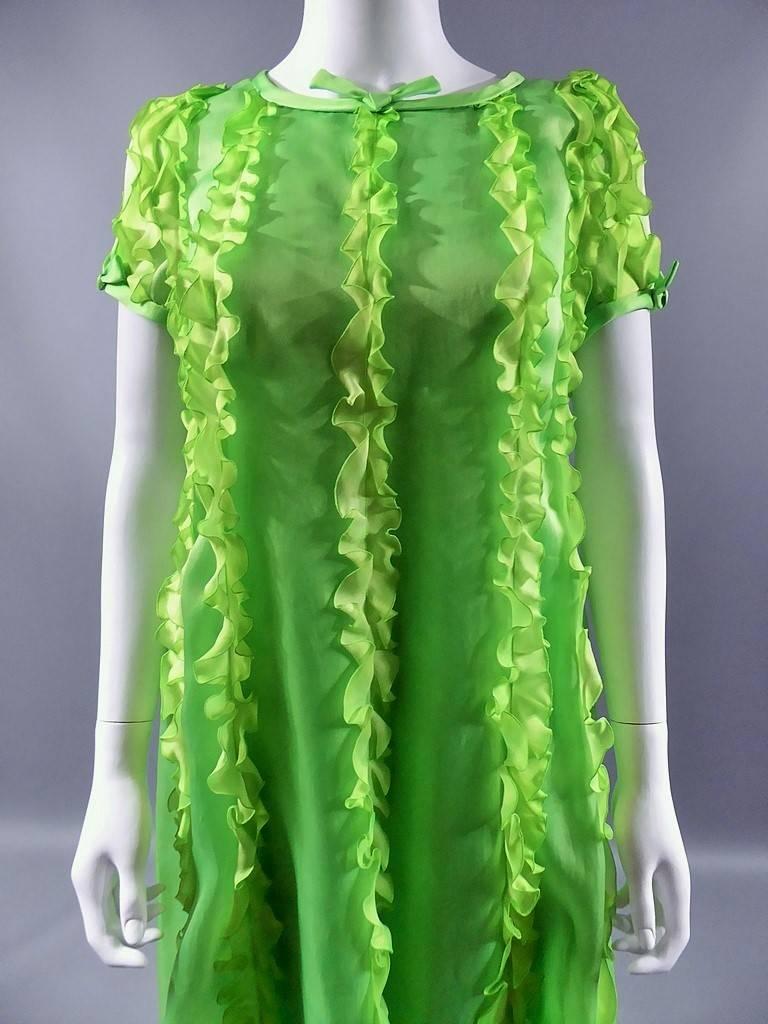 Circa end of 1960s beginning of 1970s.

France.

Long evening dress Haute Couture by André Courrèges in apple green organdy decorated work of bubbling flying in vertical bands resuming a chasuble form. Collar neck tube with a knot. Short sleeves