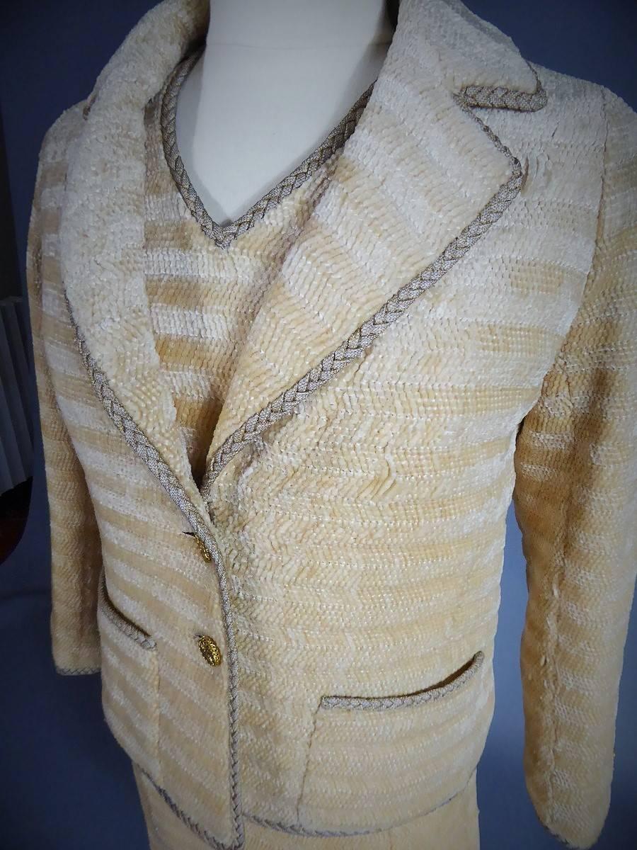 Circa 1970

France

Complete set of six pieces Chanel Haute Couture skirt suit from the 1960s. Chenille knit with brilliant effect, in horizontal stripes composed of chevrons in cream tones.
Completely piped with white cord covered with golden