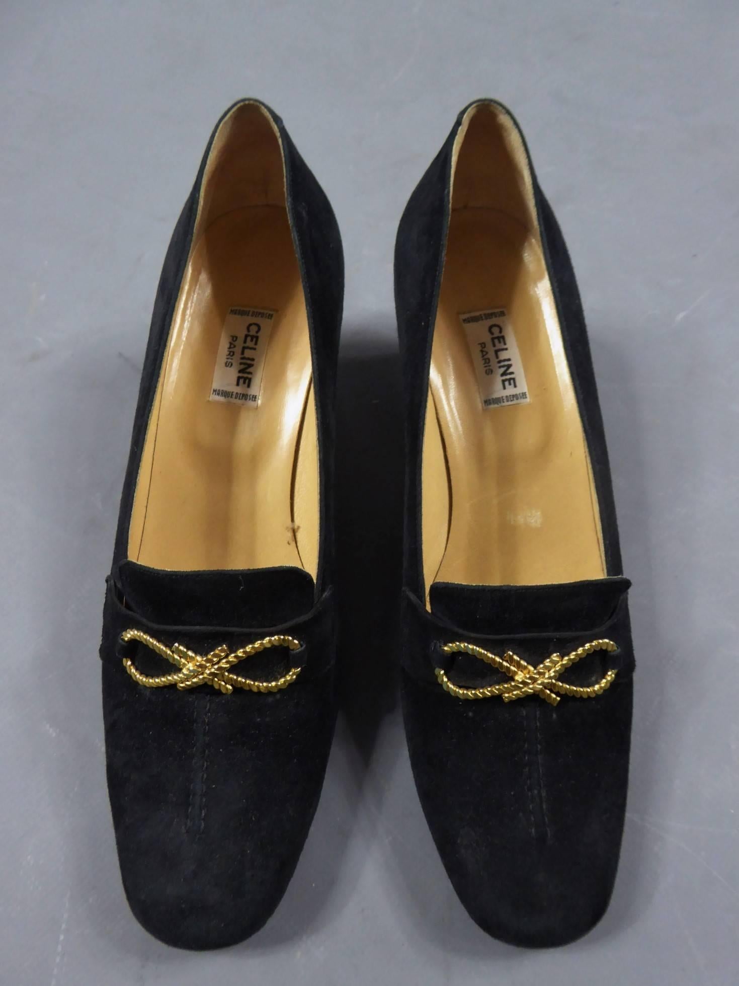 Circa 1980

France

Céline shoes in black nubuck, moccasin style. Stitches on the top and  strip. Navy knot in a 8 shape and imitation golden rope, also ending on the heel. White label black graphics saying Céline Paris Marque déposée.

Height of