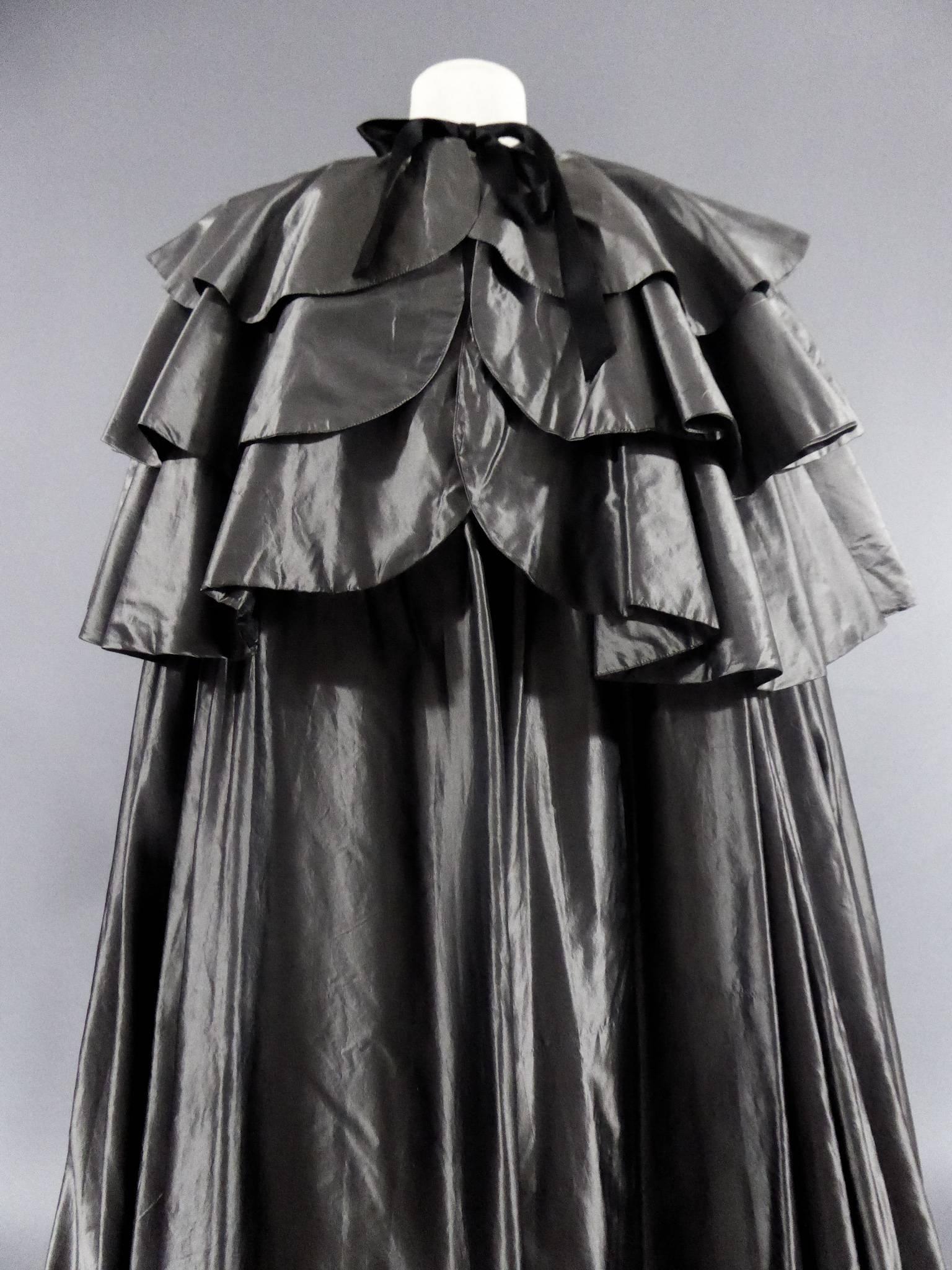 
Circa 1975

France

Cape of Princess Lilian of Belgium. Model having been exhibited at the Christian Dior Museum in Granville. Cape of big night way cochet, gray. Hollow-folded and flatter shoulders and three-tiered split-backs. Taffeta silk silver