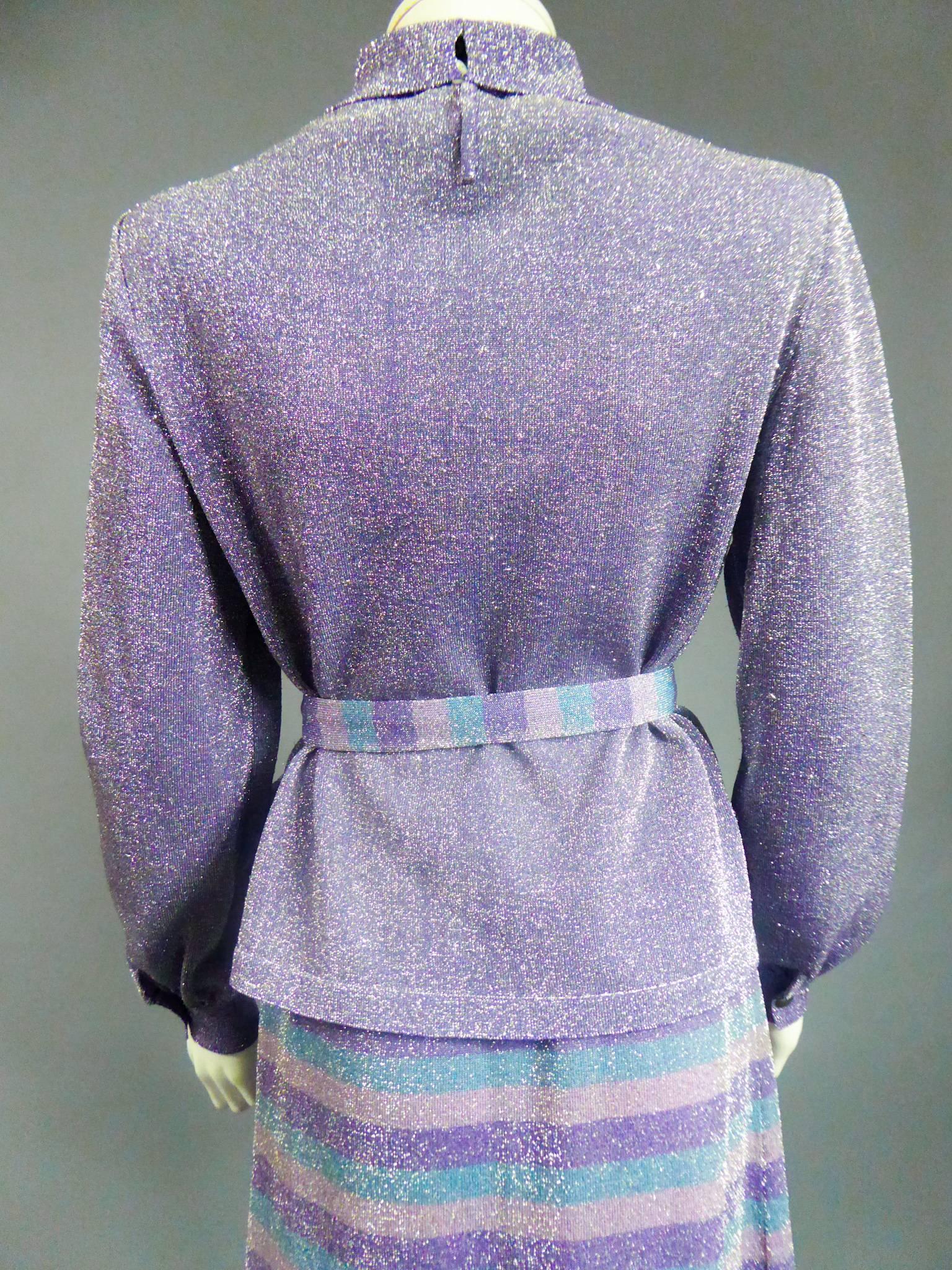 Circa 1980
France
Pierre Balmain three-piece knitwear set in silver and purple lurex. Long-sleeved, tight-fitting top with cuffs. Small turtleneck closing with invisible staples. Long flared skirt with elastic waist, petrol blue stripes, powder pink