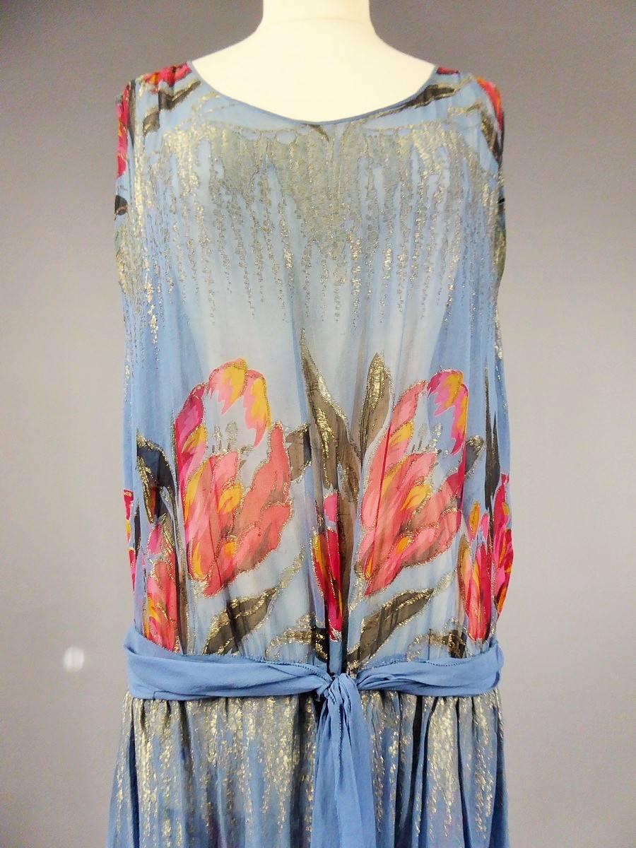 Circa 1920/1925

France Paris 

Beautiful Haute Couture Charleston style dress from the Roaring Twenties. Printed chiffon available with large red, pink, orange and black tulips. Lamé work with silver wire in stalactite. Fabric shaped flat before