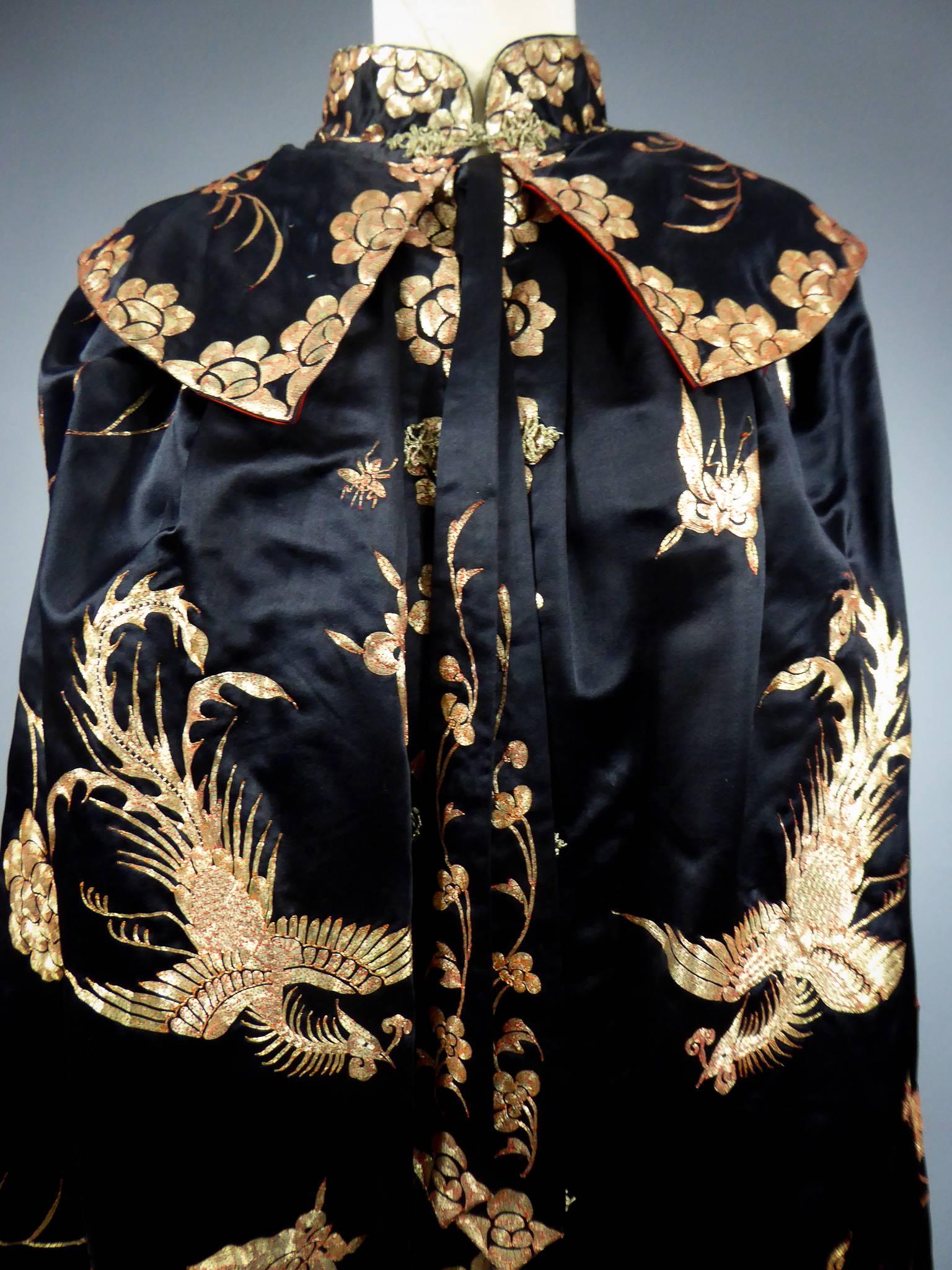 First half of the 20th century
China for European fashion
Amazing cape or ball coat embroidered in China for European fashion circa 1920 (?). Black waxed satin delicately embroidered with gold threads with a paper core, attached to the red thread.