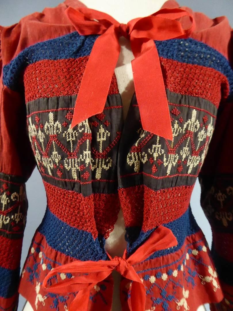 Circa 1920
France
Slav embroidered bodice probably made for fashion in France and dating from 1923. Turkey-red cotton stripes and brown embroidered cross stitch of red and indigo cotton yarn. Alternation of blue and red crochet knit band. Slav or
