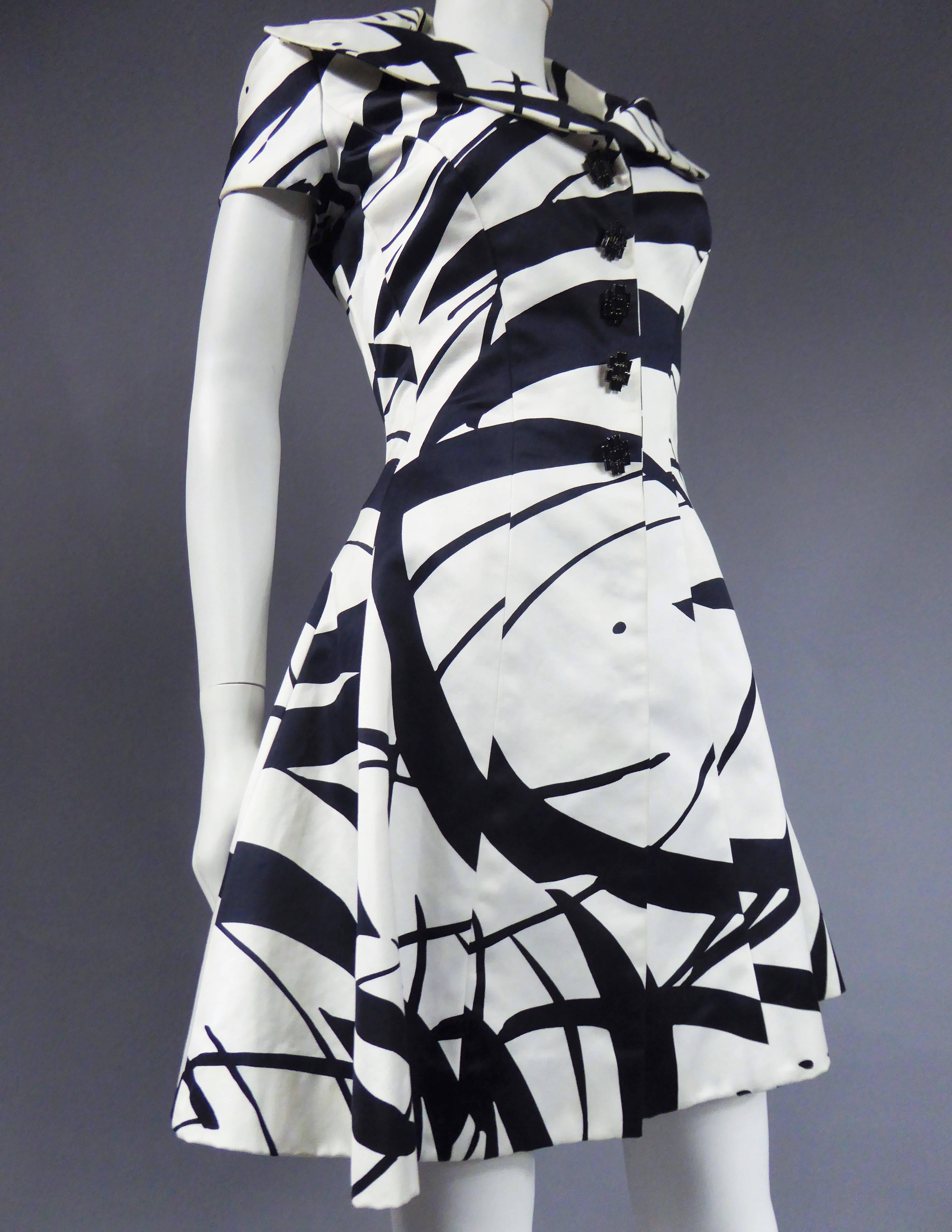 Circa 1985/1990

France

Ted Lapidus dress in thick printed silk satin. Artistic graphic of black lines on a white background, imitating thin and large brush strokes. Closes with five black Crystal jewelry buttons concealing snaps. Waisted waist,