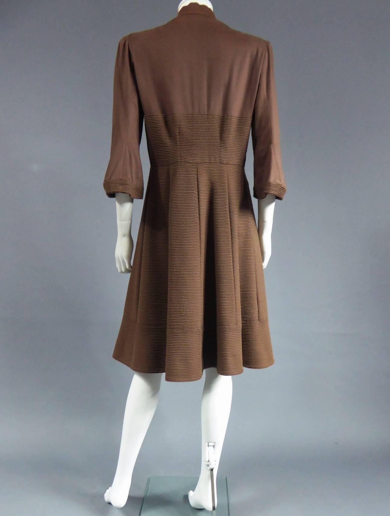 Circa 1944/1948
France Haute Couture
Interesting Haute Couture coat dress CARVEN, 6 Round Point Champs Elysee Paris, dating from the period of the Liberation of France. Very fine chamois alpaca à bourrelets with matching threads sewn in parralel