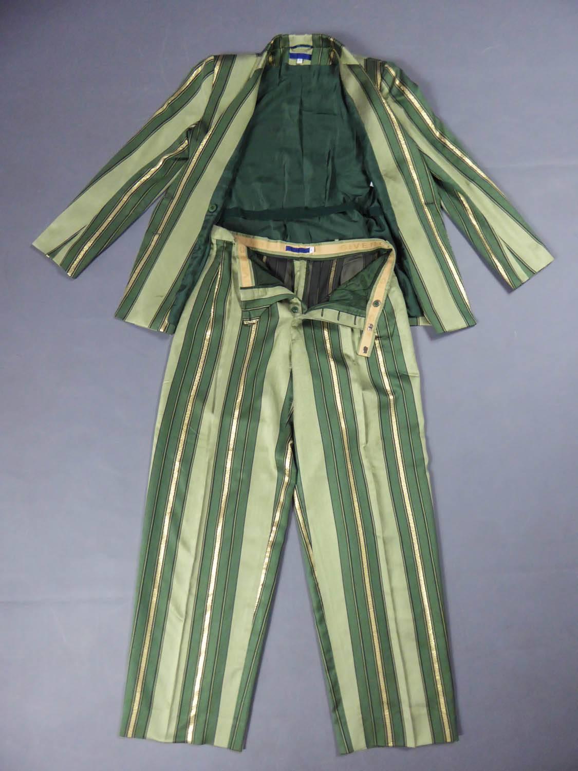 Circa 1990

France

Pantsuit Givenchy in silk and lurex from the early 90s. Wide stripes in gradiation from light green to dark green, underlined with silver lurex bands. Men's wardrobe inspiration from the 30s. Fitted jacket with large lapels and