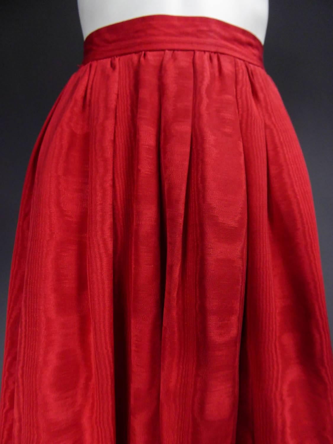 Circa 1978

France

Vermilion red silk skirt from the Yves Saint Laurent Ballets Russes Collection at the end of the 70's. A folk-inspired skirt in silk moire and wide matching velvet ribbons applied at the bottom. Wide belt underlined the waist.