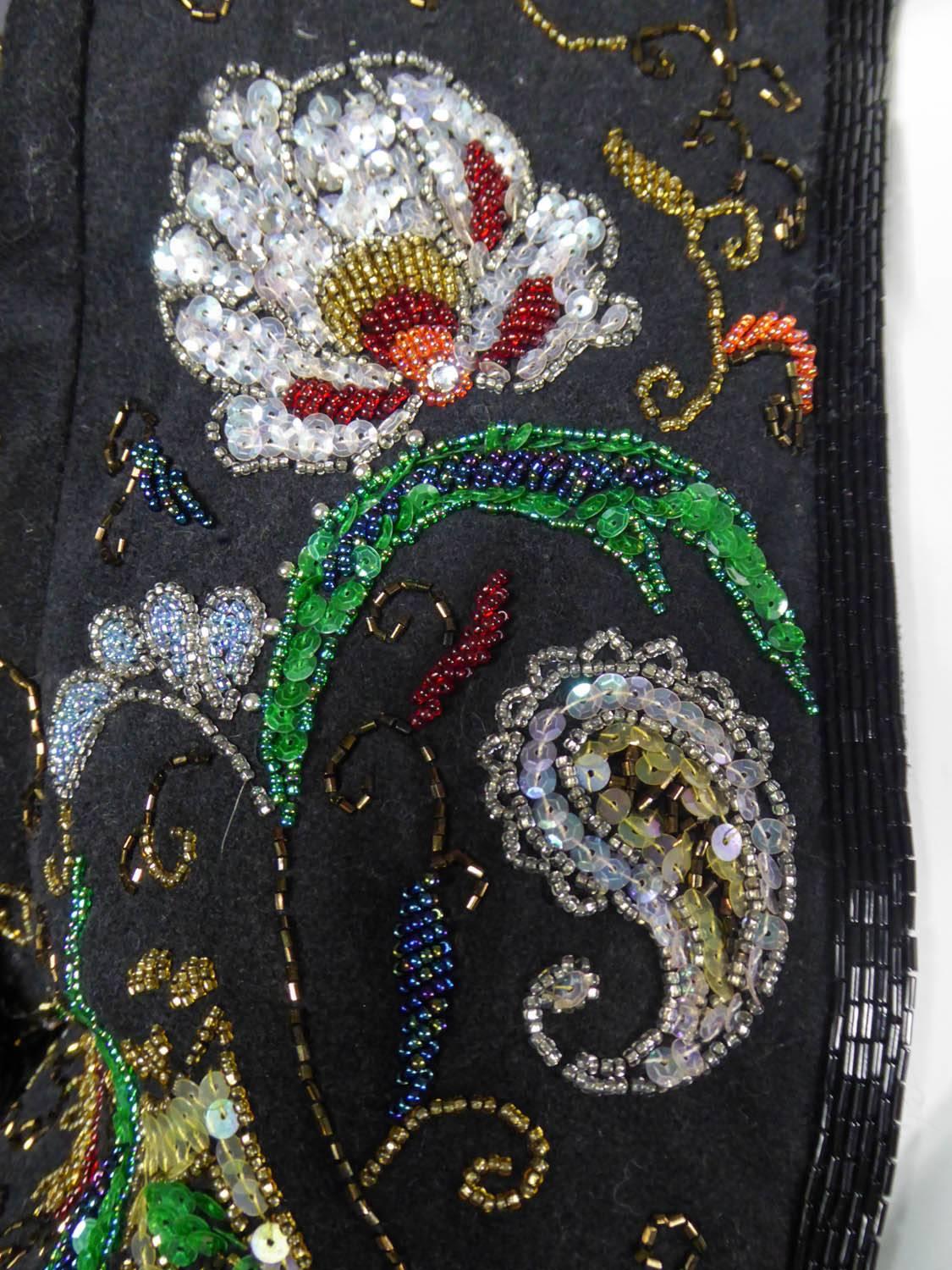 Circa 1988 - 1990

France

Yves Saint-Laurent Rive Gauche bolero with long sleeves and shoudelr pads. Black wool felt, embroidered with glitter, sequins and tubular sequins polychrome and iridescent in the dominant colors of green, pearly, purple,