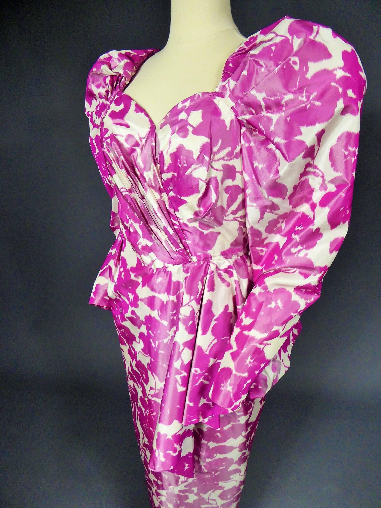 Circa 1980

France

French Fuchsia silk evening Couture dress Anonymous from the 80s. Cream silk and pink taffeta with changing effect, with floral patterns printed on the warp. Pleated and boned bustier and long gigot-sleeves. Over-skirt asymmetric