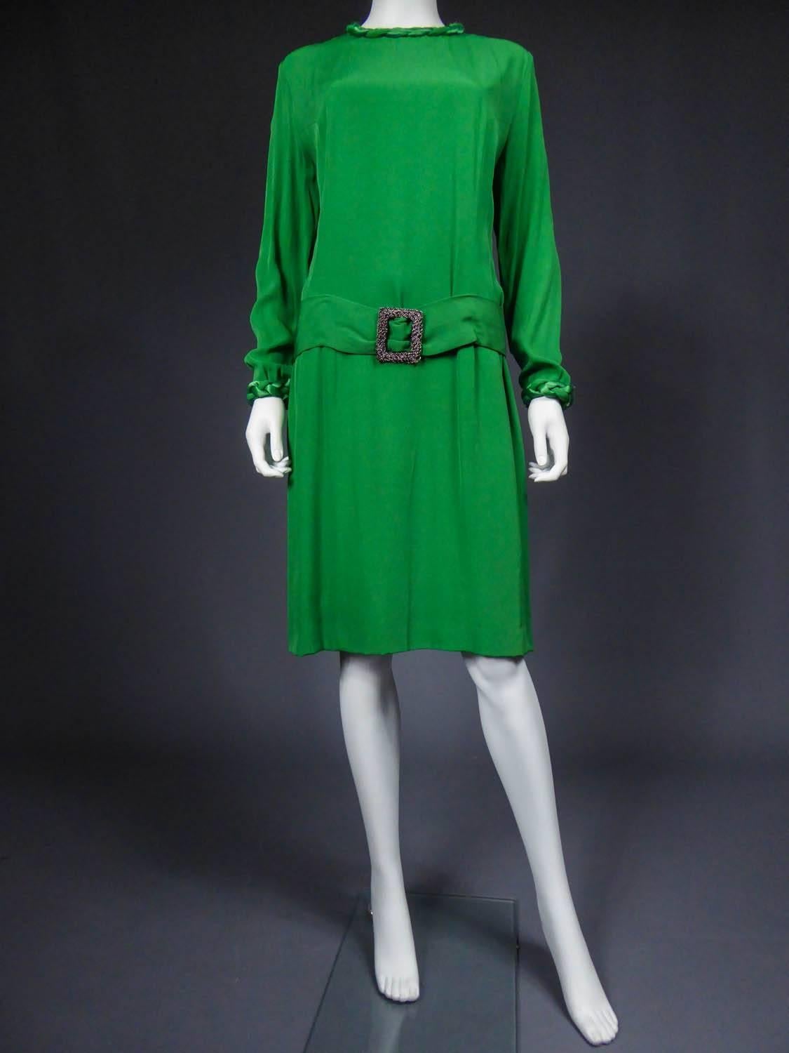 Circa 1940/1960

France

Cocktail dress in emerald green silk ottoman from the 60s. Large matching matt and shiny braids in padded cords at the collar and cuffs. False low-waisted belt with wide buckles in steel chain. Greenish nylon lining. Label