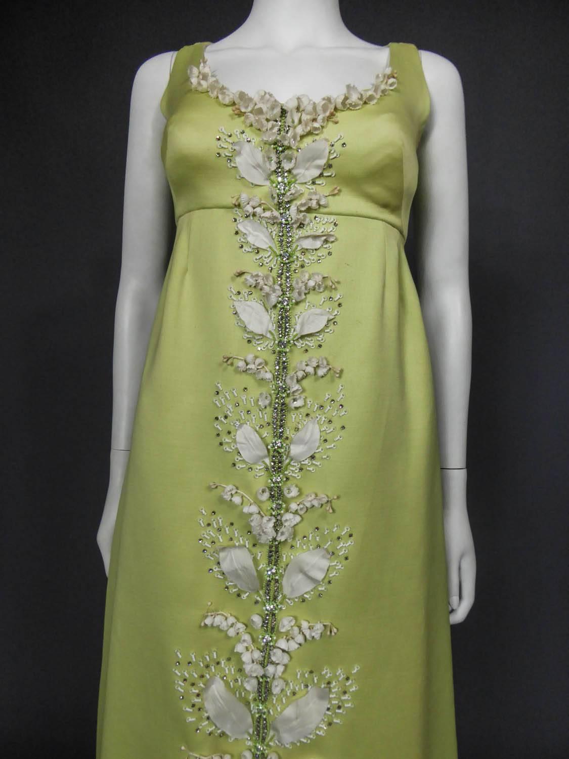 Circa 1965

Italy

Evening dress Tati in Celadon green gazar embroidered with lily of the valley from Milan in the 60s. High waist inspired by the First Empire. Low-cut neckline, the dress closes in the back with two panels decorated with a large