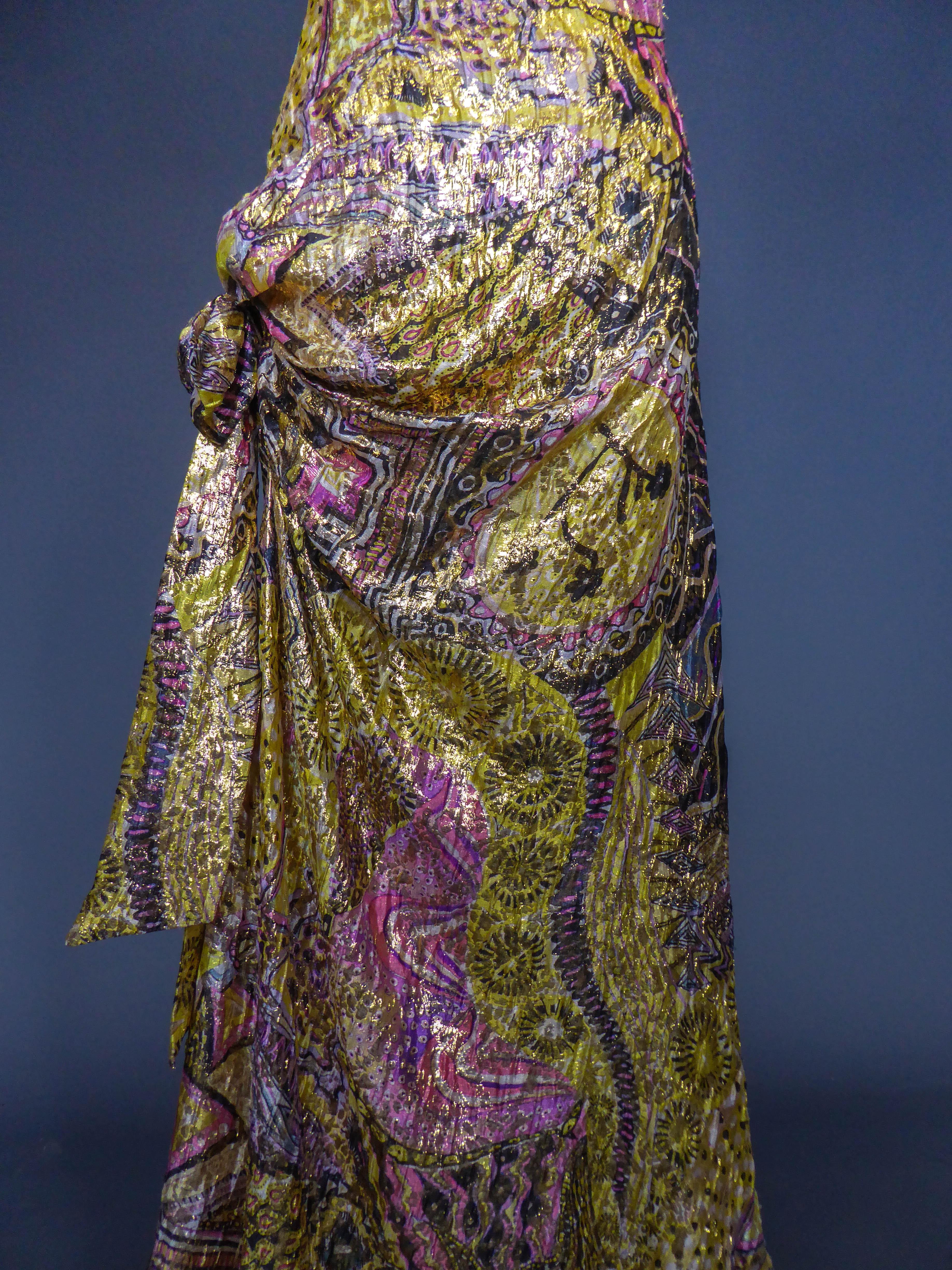 Circa 1995/2005
France

Chrisitan Lacroix Couture gold-plated silk evening dress from the 2000s. Dress with straps with a large fold of fabric on the neckline and a large bow on the hips. Shaped silk with psychedelic patterns in shades of yellow,