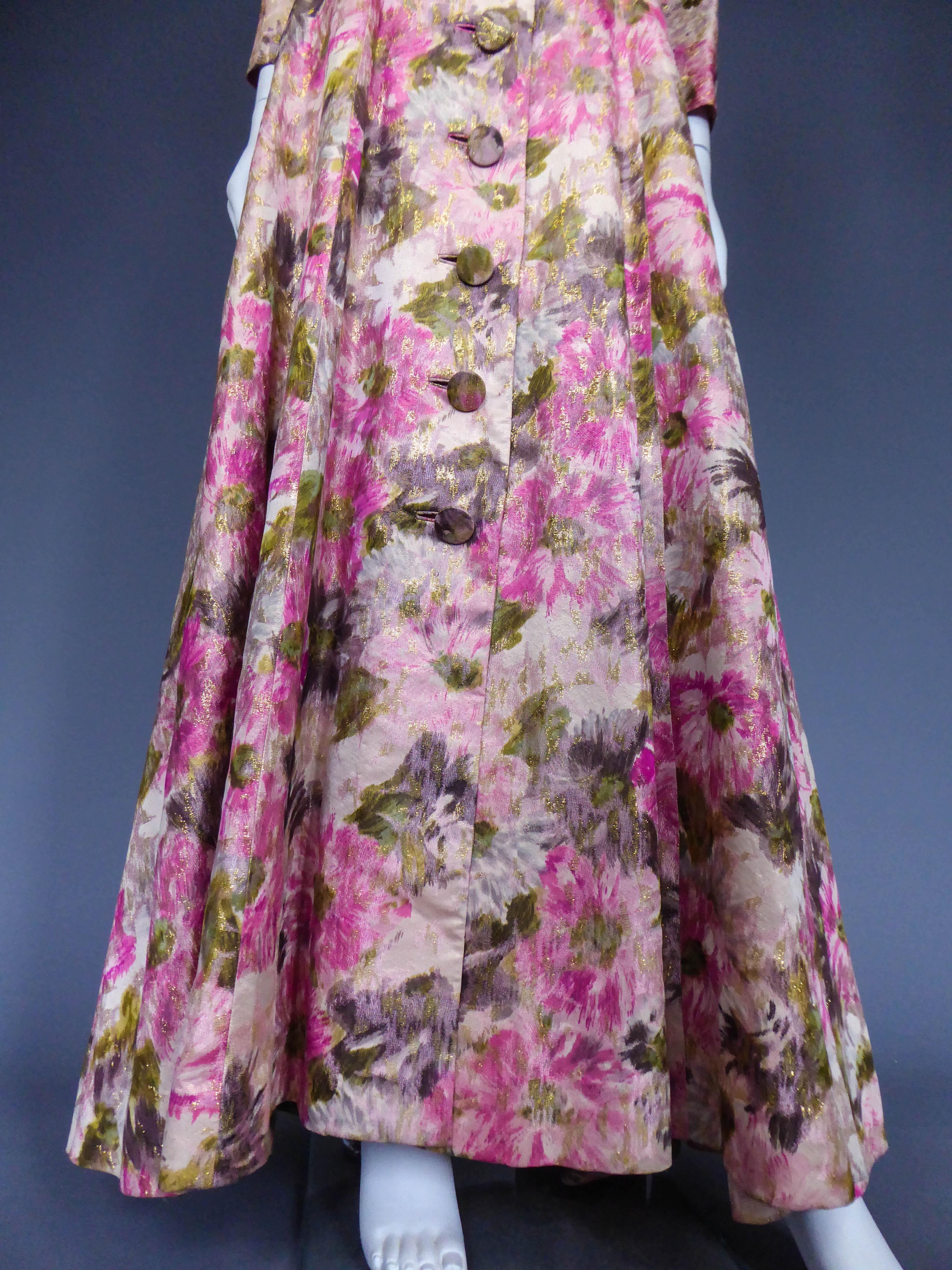 Circa 1935/1950
United States

Frock coak long dress in shaped gold-plated silk Elizabeth Arden's. Famous New York reference to 5th Avenue between the two World Wars and dressed as Hollywood stars. Decoration of large flowers printed on chain giving