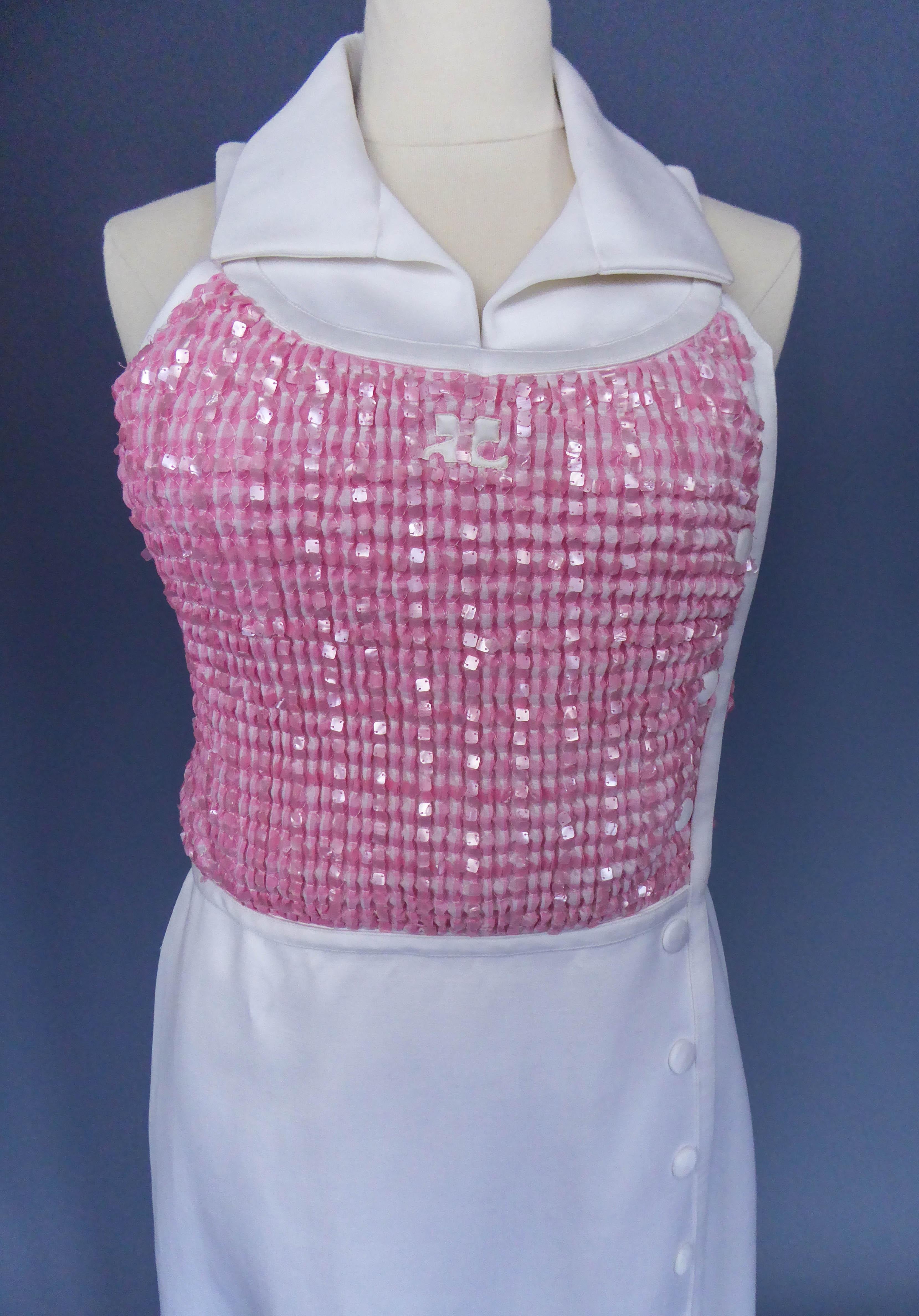 Circa 1970/1980
France

Long dress in white cotton jersey and pink sequins embroidery by André Courrèges Couture from the 1970s. Sleeveless dress in thick ecru jersey underlined with a matching overstitched band. Bustier in checkered pink gingham