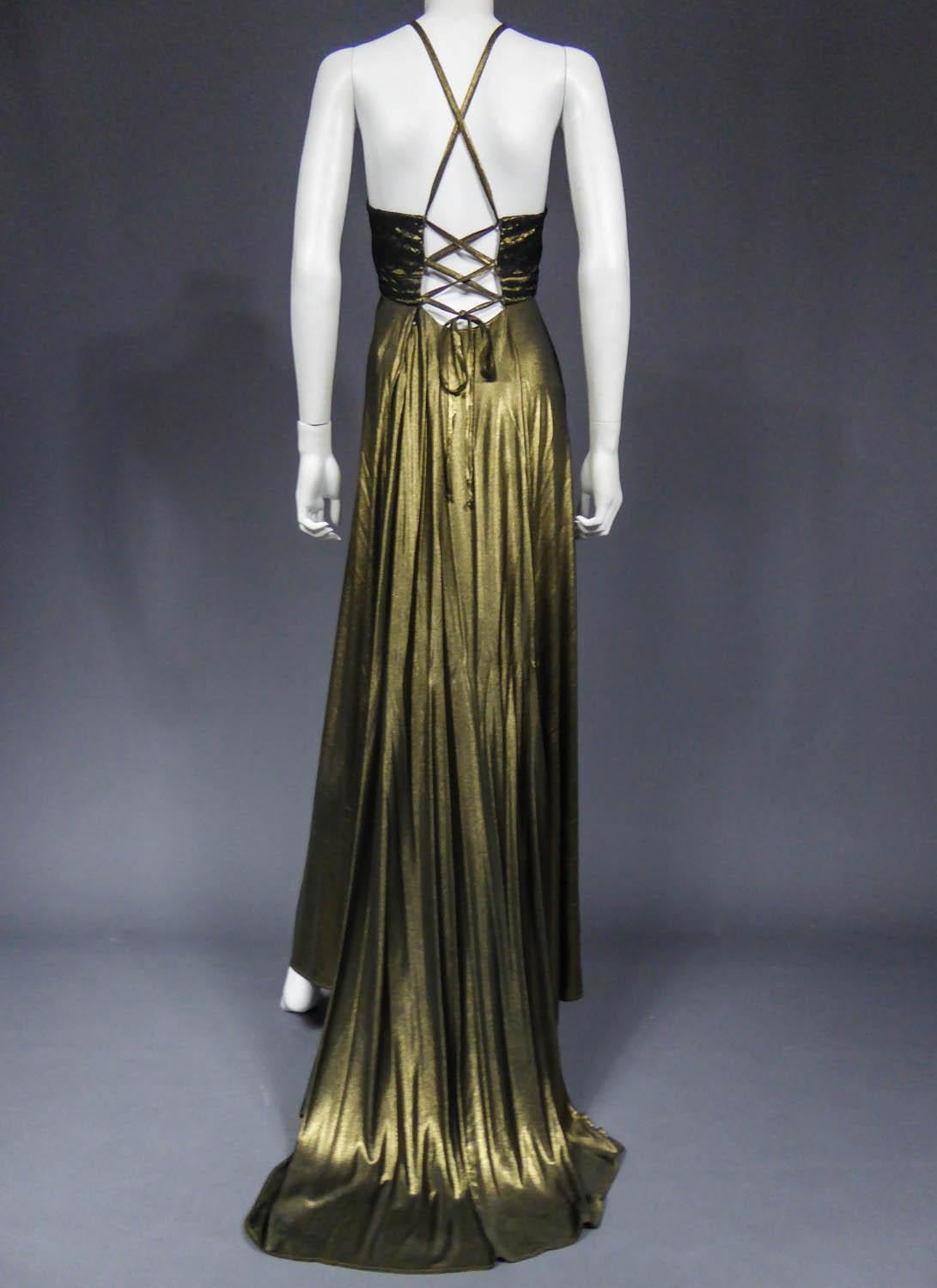 Circa 1995
France

Christian Lacroix haute couture evening gown in copper golden lamé from the 1990s. Savant lacing of back straps that cross at the back and at the chest. The latter is covered with black lace. Small train skirt of great elegance.