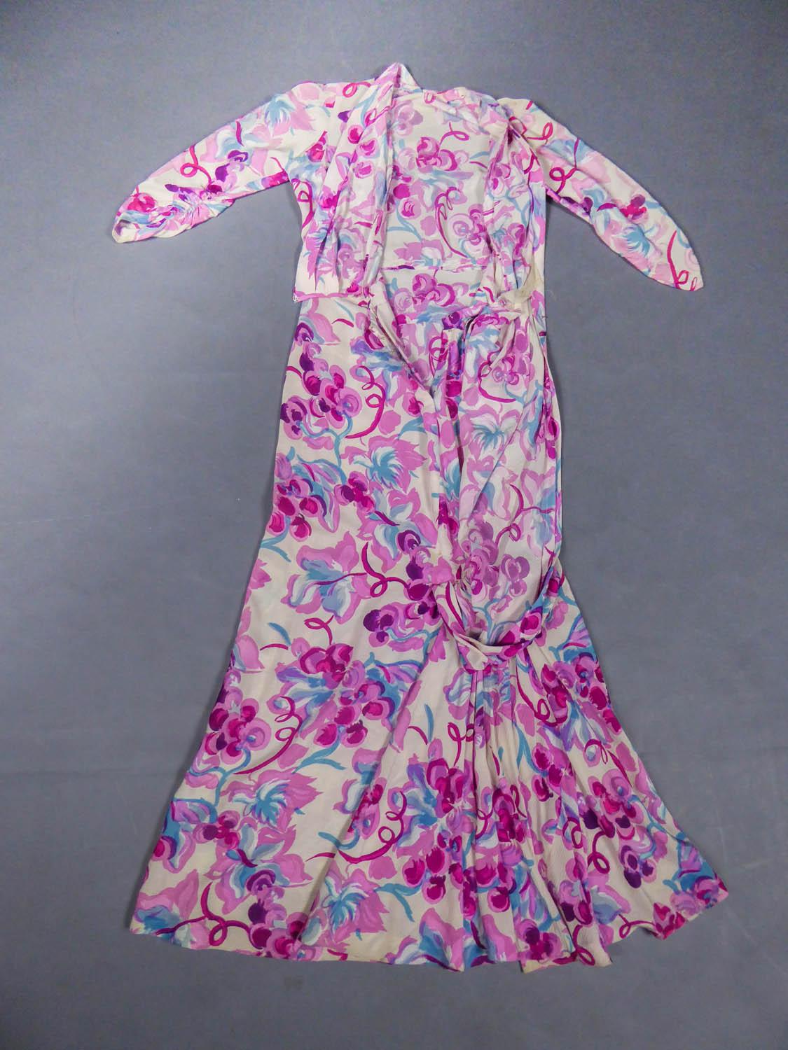 Circa 1940
France

Summer dress in cream silk crepe with patterns of grapes in pink, fuchsia, aubergine and sky blue. Sleeves three-quarter, closes on the front by a drape effect. Slightly damaged on the closure of the dress, otherwise very good