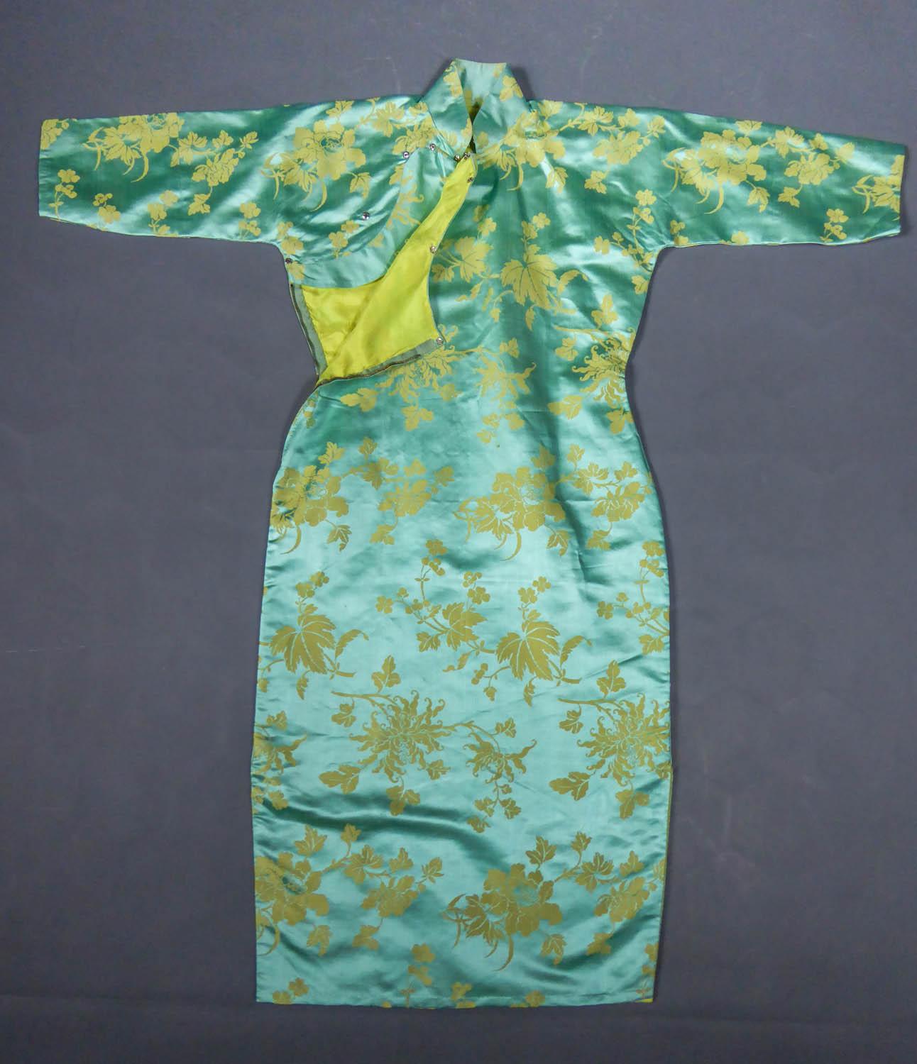 Circa 1950/1960
France

Skin-tight chinese dress called qipao or cheongsam in sky-blue and straw-yellow silk damask dating from the years 1950/1960. Damask sky-blue satin background with large stylized flowers, peonies and / or chrysanthemums (?) in