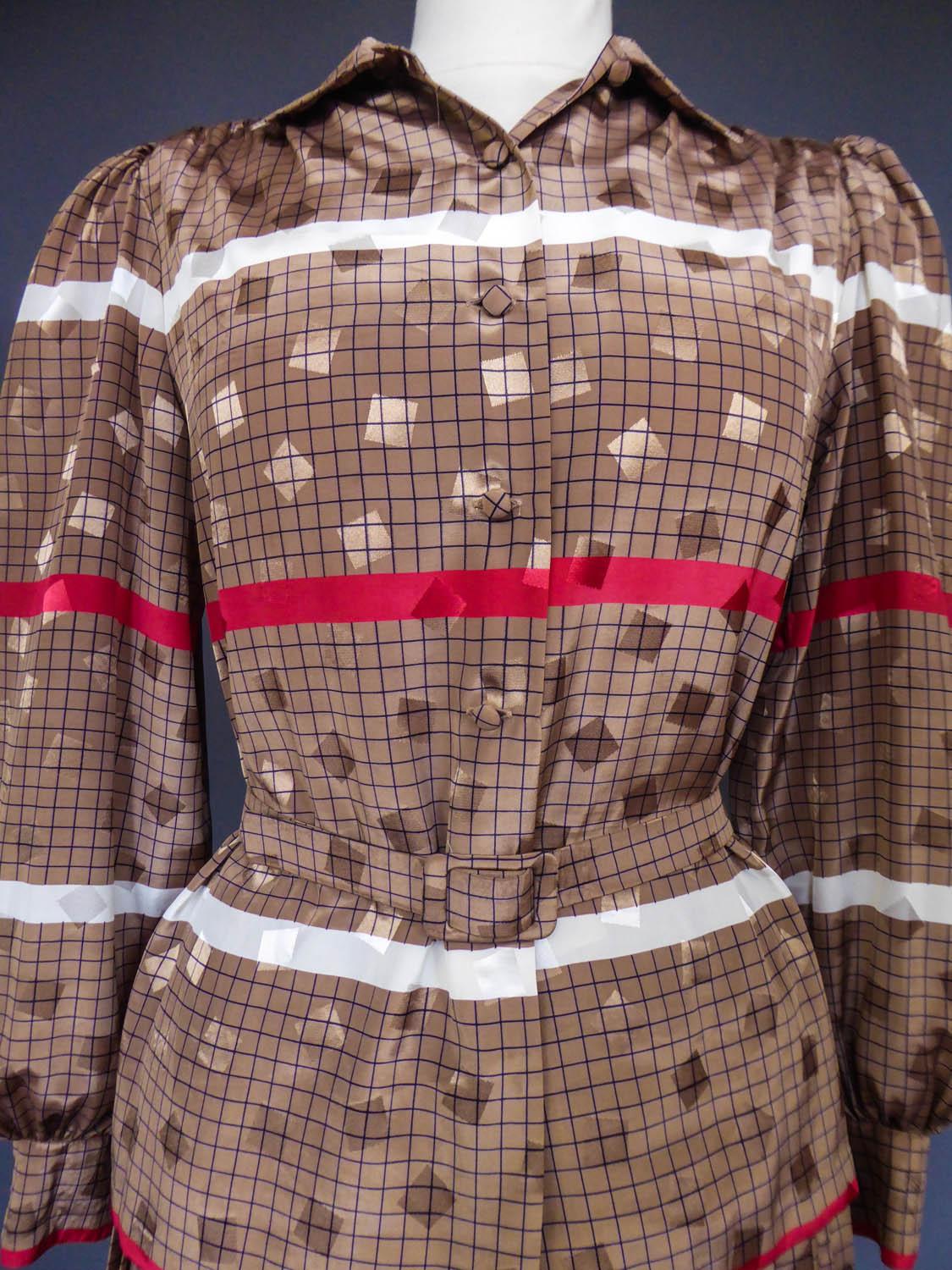 CIRCA 1980
Frankreich

Faltenrock und Bluse aus braunem Polyester mit schwarzem Karo, rosa und weißen Streifen und schillernden braunen Würfeln aus den 1980er Jahren. Ohne Etikett, aber Cacharel sehr wahrscheinlich Typ. Bluse mit Puffärmeln, die in