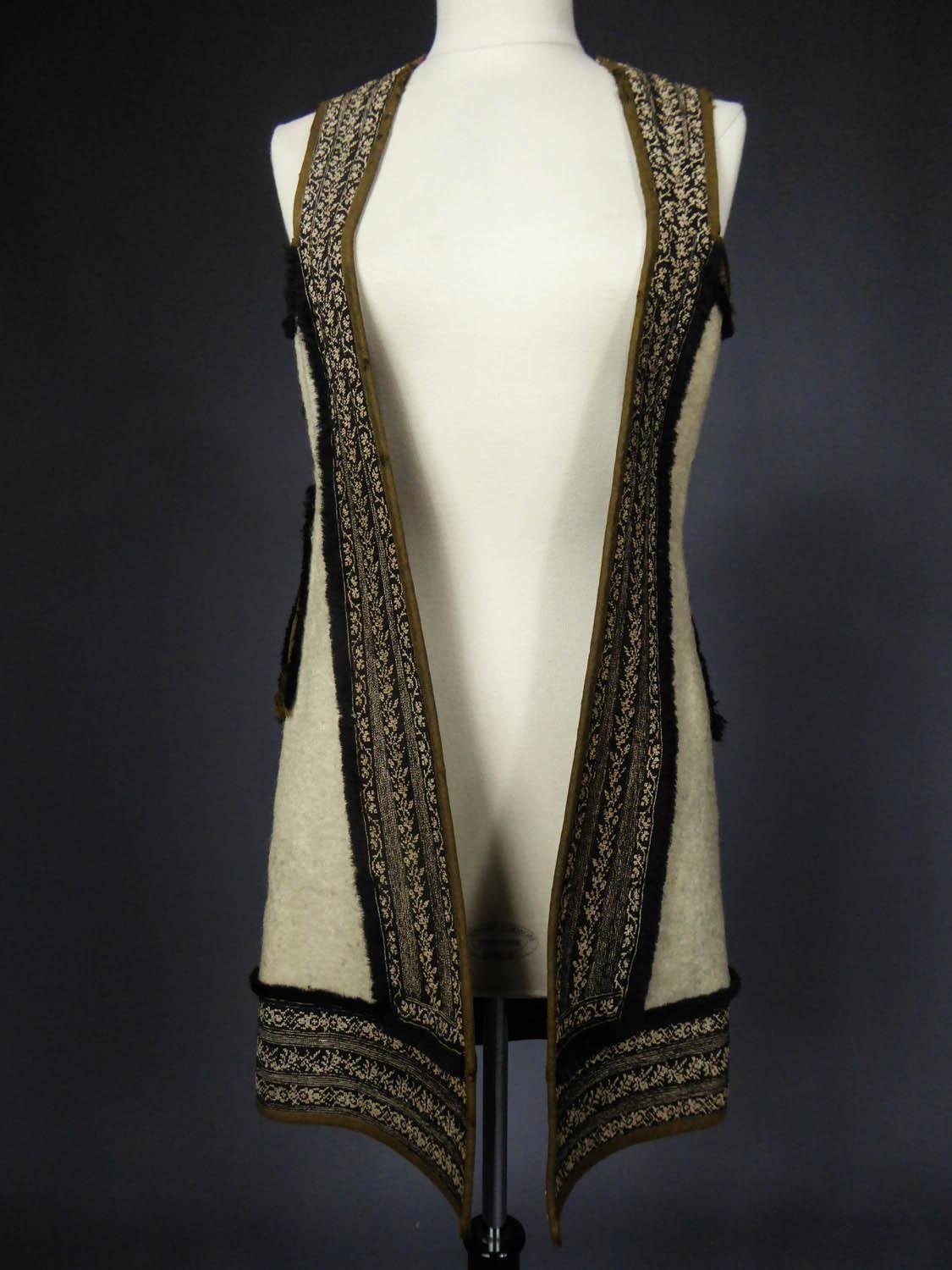 Circa 1900
Greece - Macedonia - Albania (?)

Long vest or sleeveless coat in thick wool finely embroidered at the petit point dating from the early twentieth century and originating in Macedonia or Albania. Thick fluffy ivory wool sewn of black